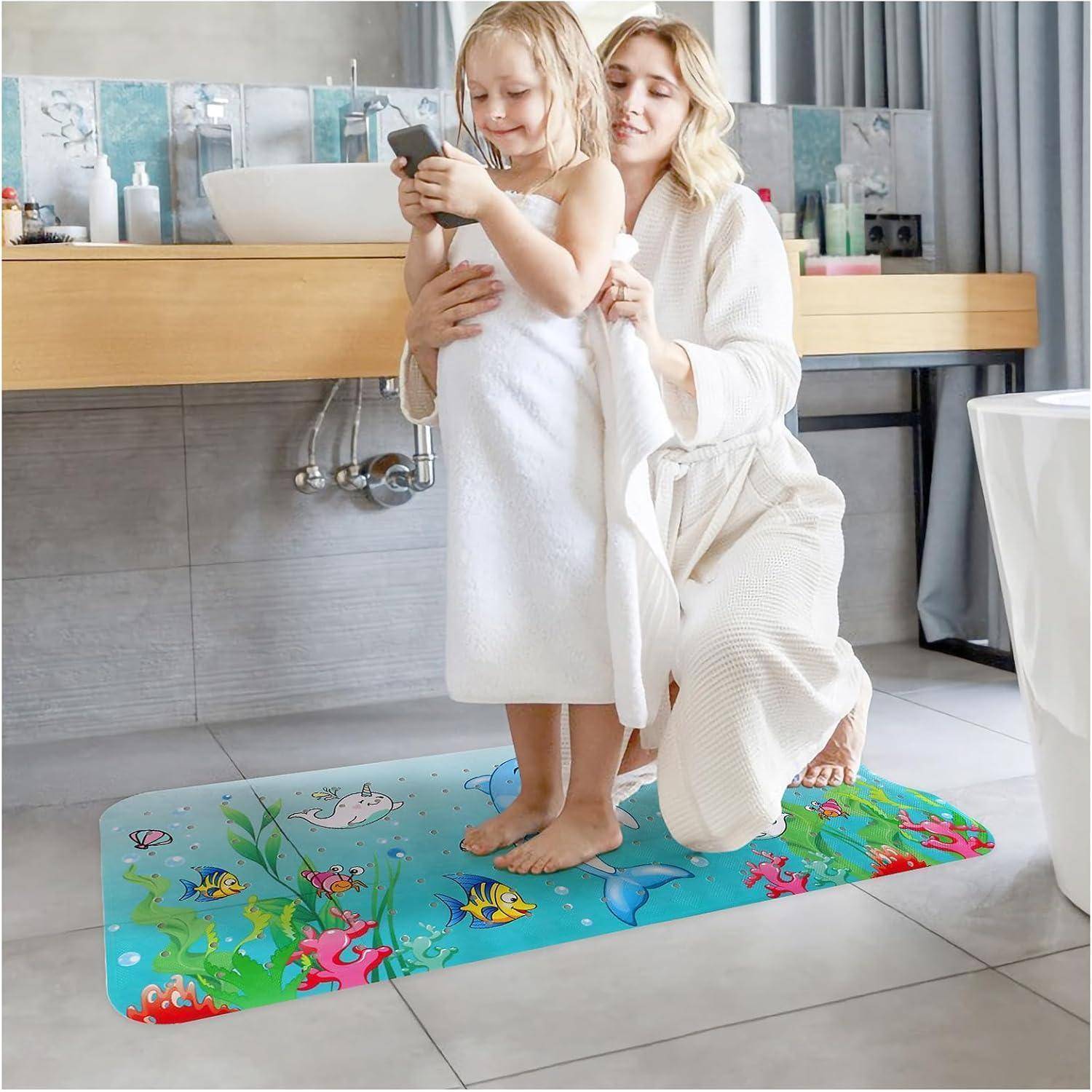 Eine Frau in einem Bademantel hilft einem Kind, ein Smartphone zu benutzen, während sie auf einer bunten Badmatte im Badezimmer steht.