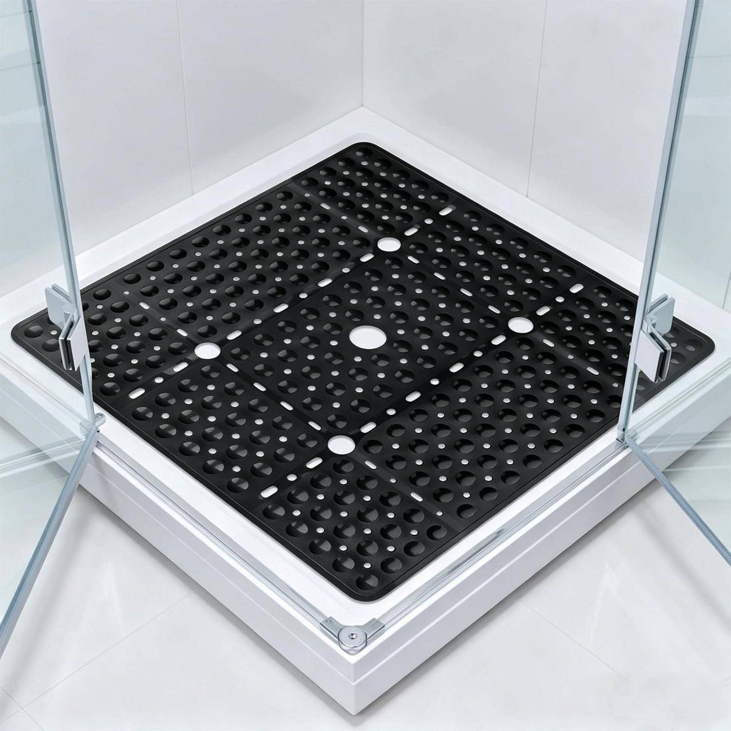 Schwarzes durchlöchertes Duschwannengitter mit quadratischer Ablaufabdeckung in einer gläsernen Eckduschkabine.