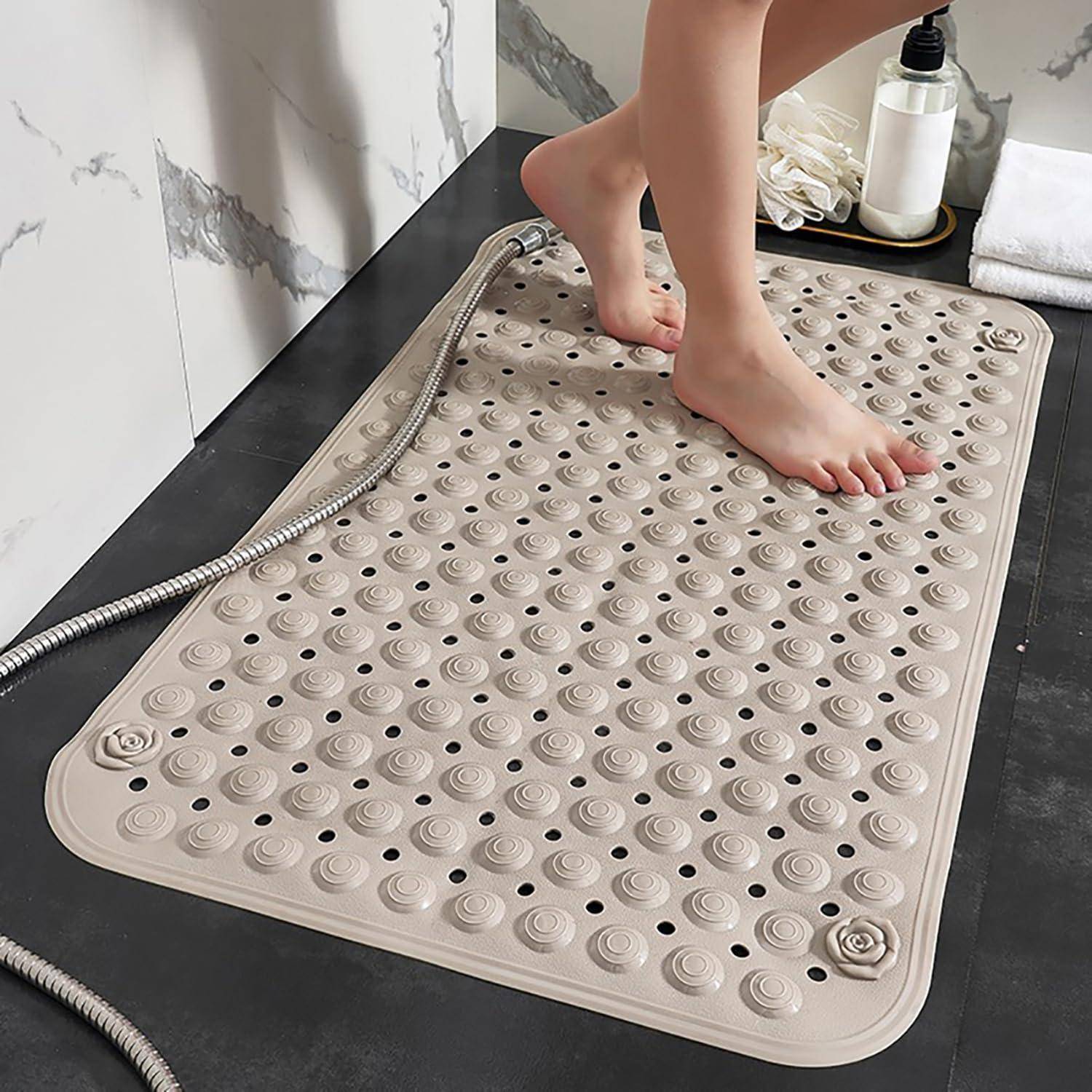 Person, die eine strukturierte Dusch-Fußmassage-Matte in einem Badezimmer benutzt, mit einem Duschschlauch und Toilettenartikeln in der Nähe.