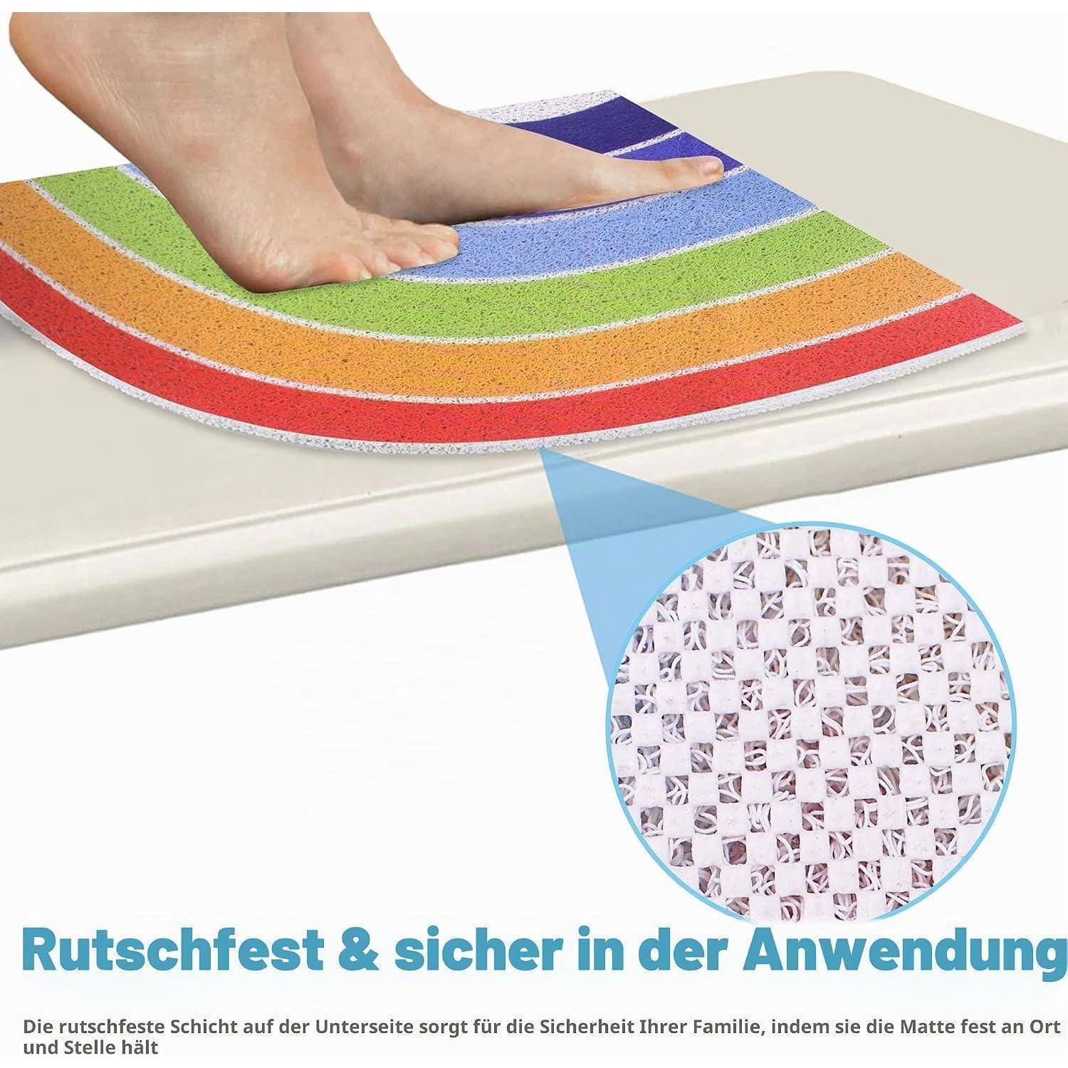 Füße stehen auf einer farbenfrohen Badenmatte auf einer gekachelten Oberfläche, mit einer Nahaufnahme, die die rutschfeste Unterseite und deutschen Text über sichere, gesicherte Verwendung zeigt.