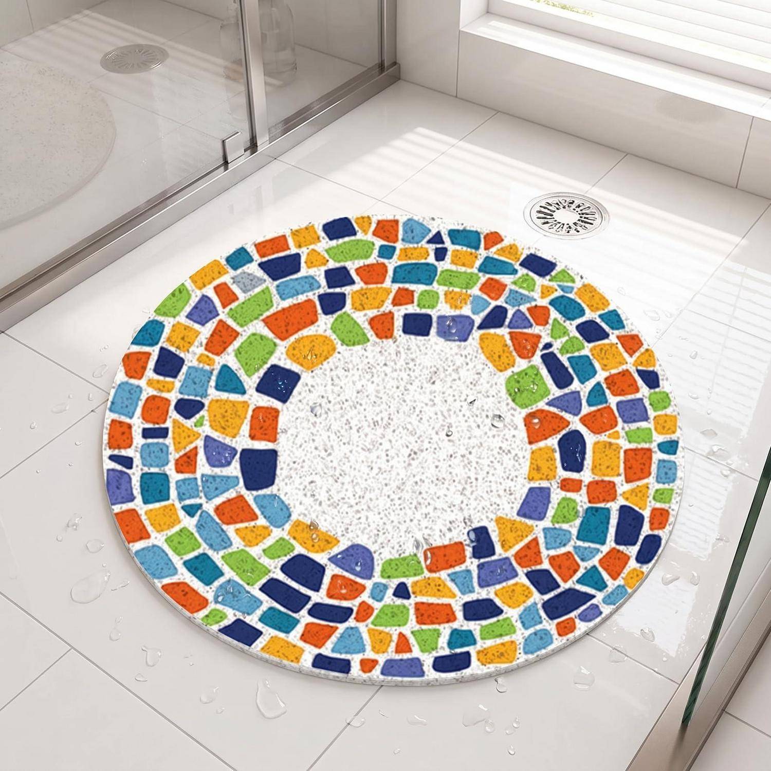 Farbenfrohe runde Mosaikbadematte oder Duschvorleger auf einem weiß gekachelten Badezimmerboden neben einer Glastür zur Dusche, mit sichtbaren Wassertropfen.