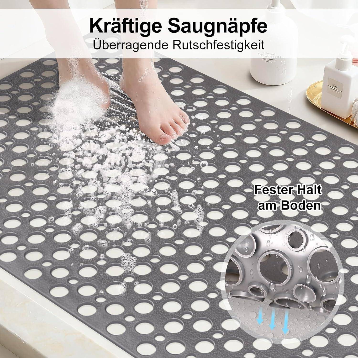 Nahaufnahme einer Badezimmermatte mit Saugnäpfen, die fest auf dem Boden halten, während ein Fuß darauf tritt; der Text besagt „Kräftige Saugnäpfe