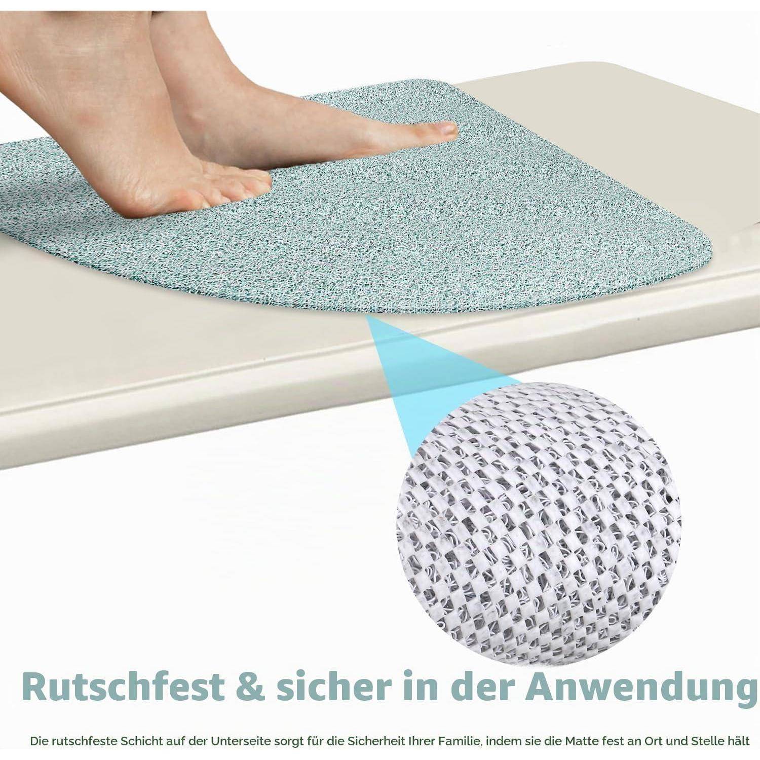 Nackte Füße stehen auf einer blauen rutschfesten Badematte auf dem Rand einer Badewanne; eine Einschubvergrößerung zeigt die strukturierte Griffoberfläche. Der deutsche Text besagt, dass sie rutschfest und sicher in der Anwendung ist.