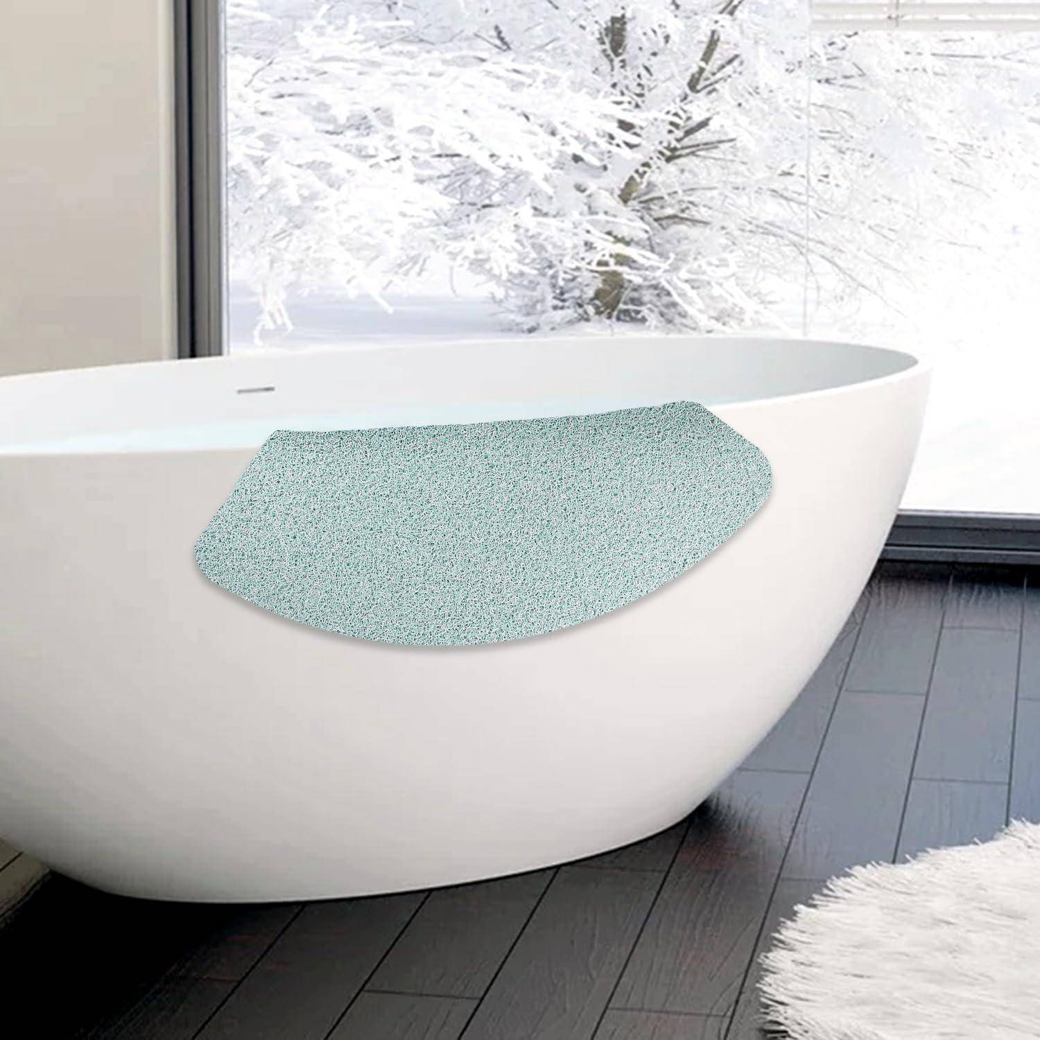 Moderne freistehende weiße Badewanne mit strukturiertem blauem Badekissen in einem hellen Badezimmer