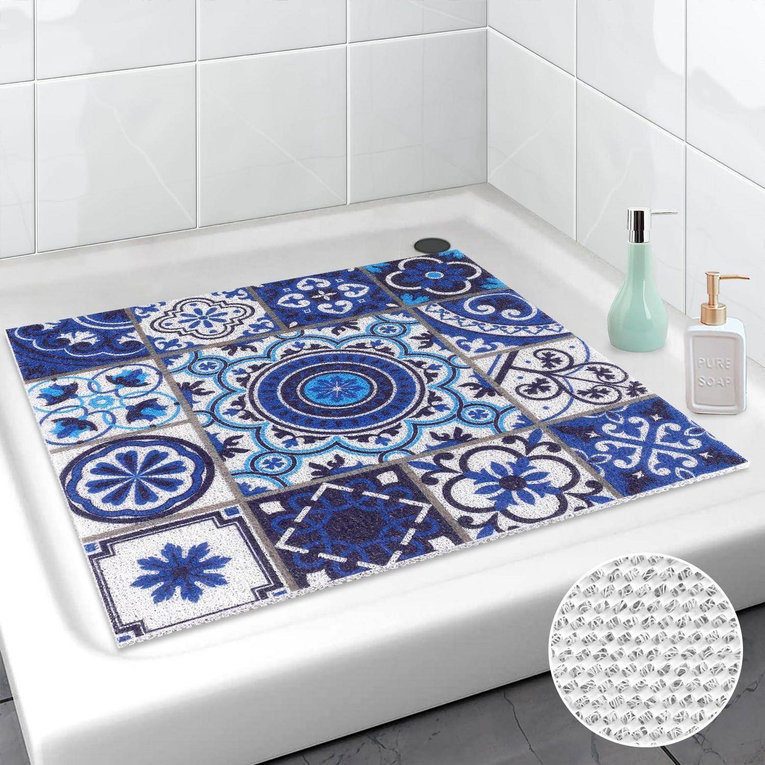 Blau-weiße gemusterte rutschfeste Badmatte auf einem weißen Badewannenbrett, mit Toilettenartikeln daneben und einer Vergrößerung der strukturierten Griffrückseite.