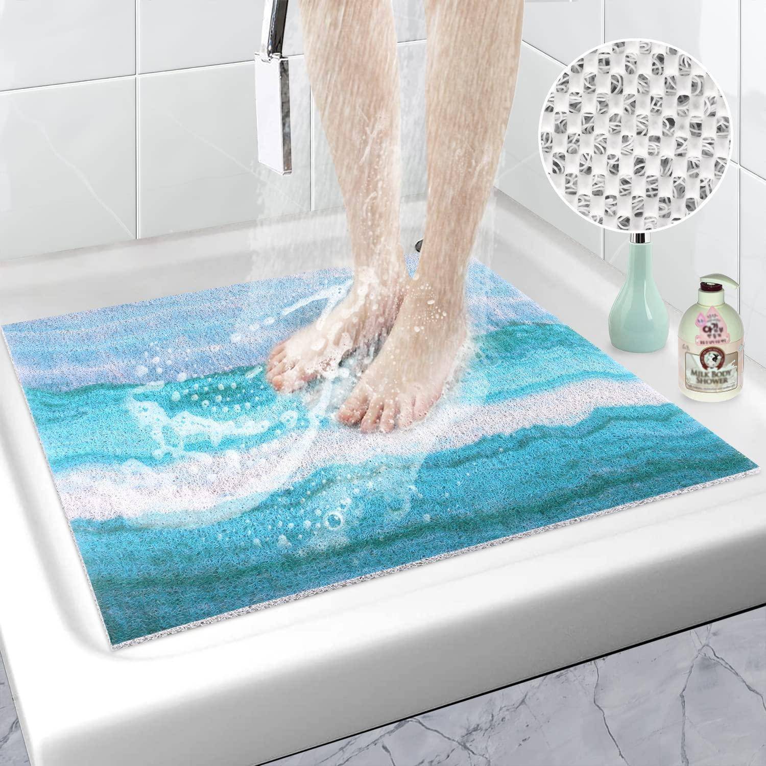 Person steht auf einer blauen Badmatte in einer Dusche und zeigt eine strukturierte, rutschfeste Oberfläche, die Wasser schnell ableitет.