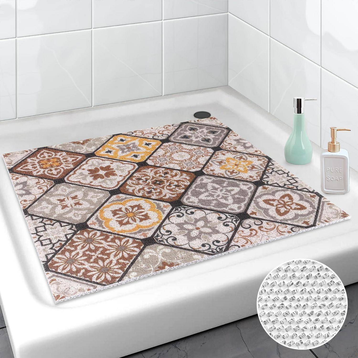 Gemusterter rutschfester Badematte in einer Badewanne platziert, mit mosaikartigen quadratischen Fliesen in Braun, Grau und Gelb.