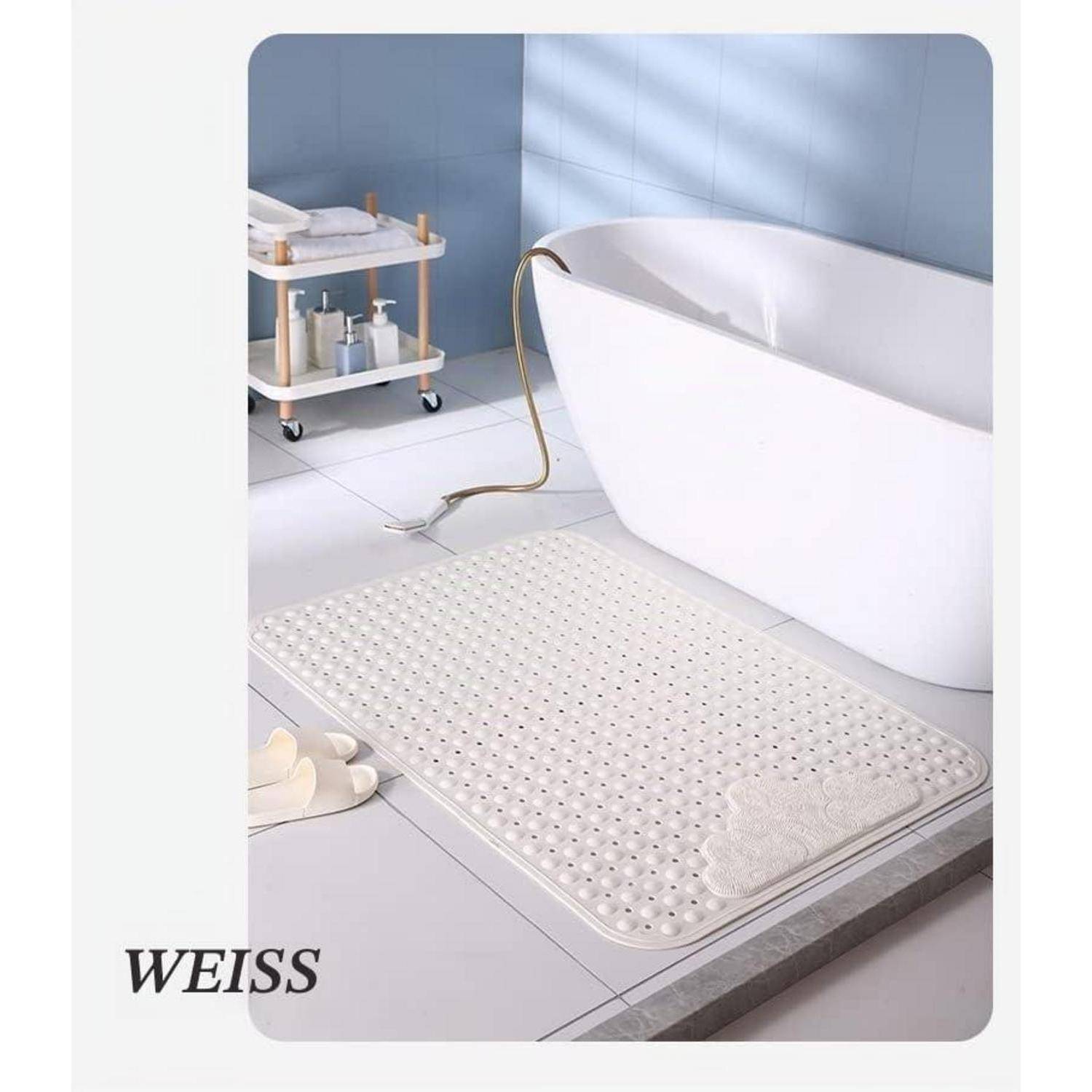 Modernes Badezimmer mit einer freistehenden Badewanne, einem fahrbaren Wagen, Hausschuhen und einer weißen strukturierten Badematte neben der Badewanne.
