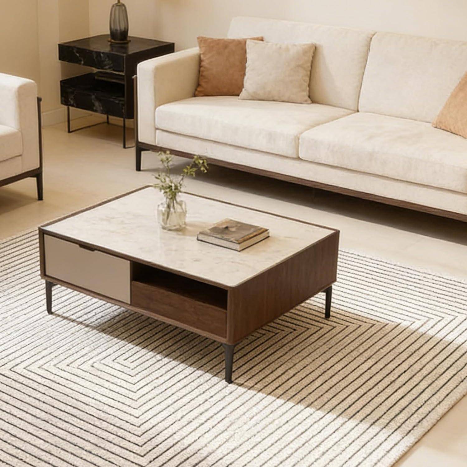 Modernes Wohnzimmer mit beigem Sofa, Couchtisch mit Marmorplatte, gestreiftem Teppich und kleinem Beistelltisch in einem sauberen, neutralen Interieur.