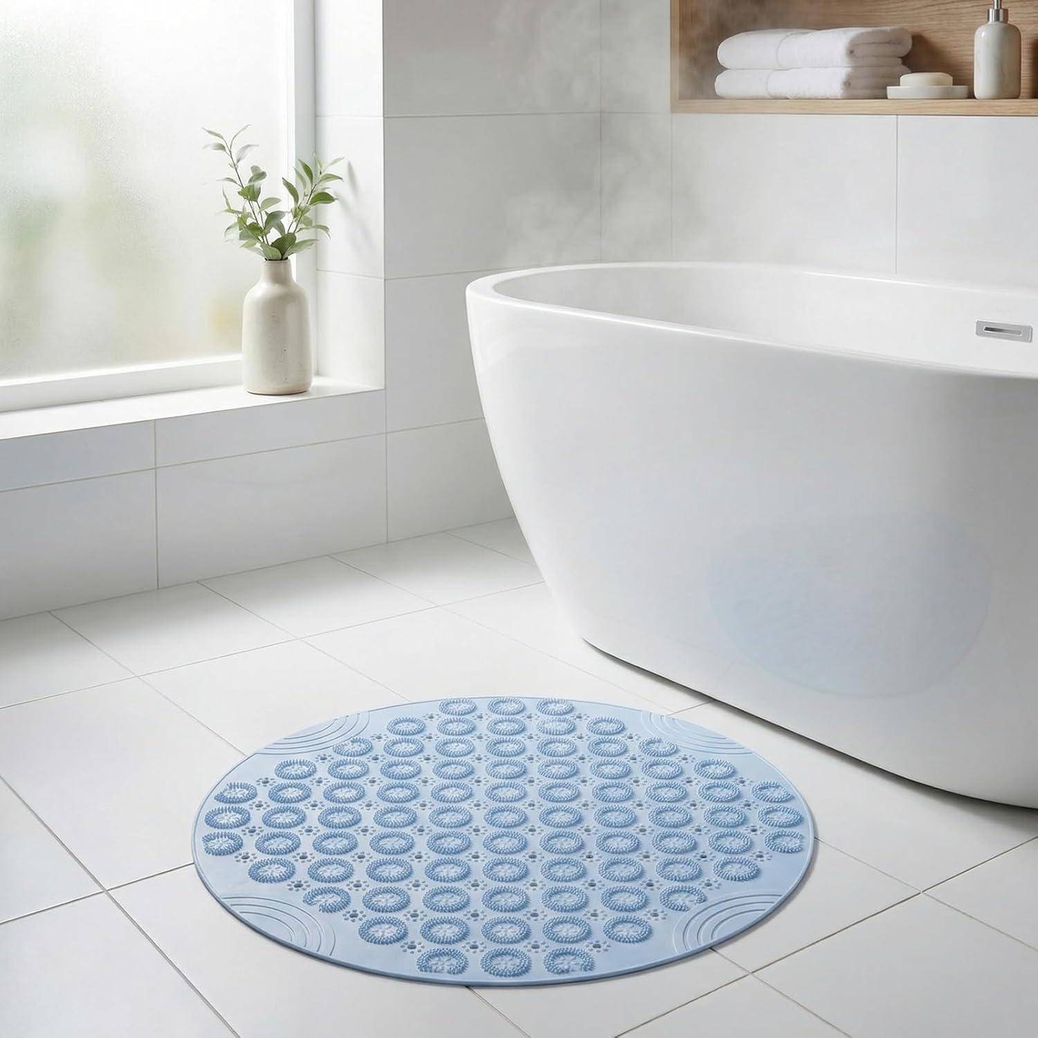 Modernes weißes Badezimmer mit einer freistehenden Badewanne, Milchglasfenster, Handtuchwärmer und einer runden blauen gemusterten Badematte auf dem Boden.
