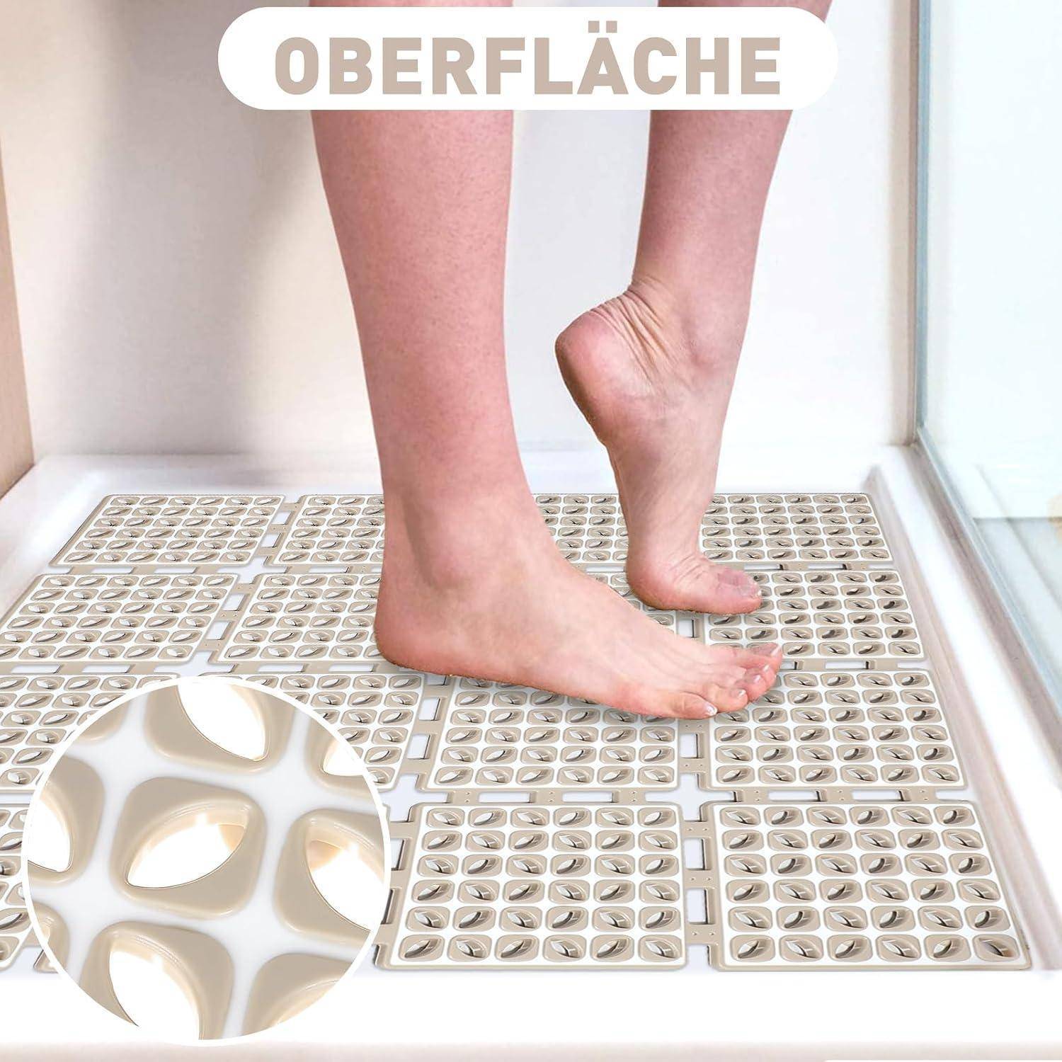 Nackte Füße stehen auf strukturierten Duschbodenfliesen, mit einer Nahaufnahme-Einsatz, die die Fliesenoberfläche zeigt und das Wort "OBERFLÄCHE"" darüber.