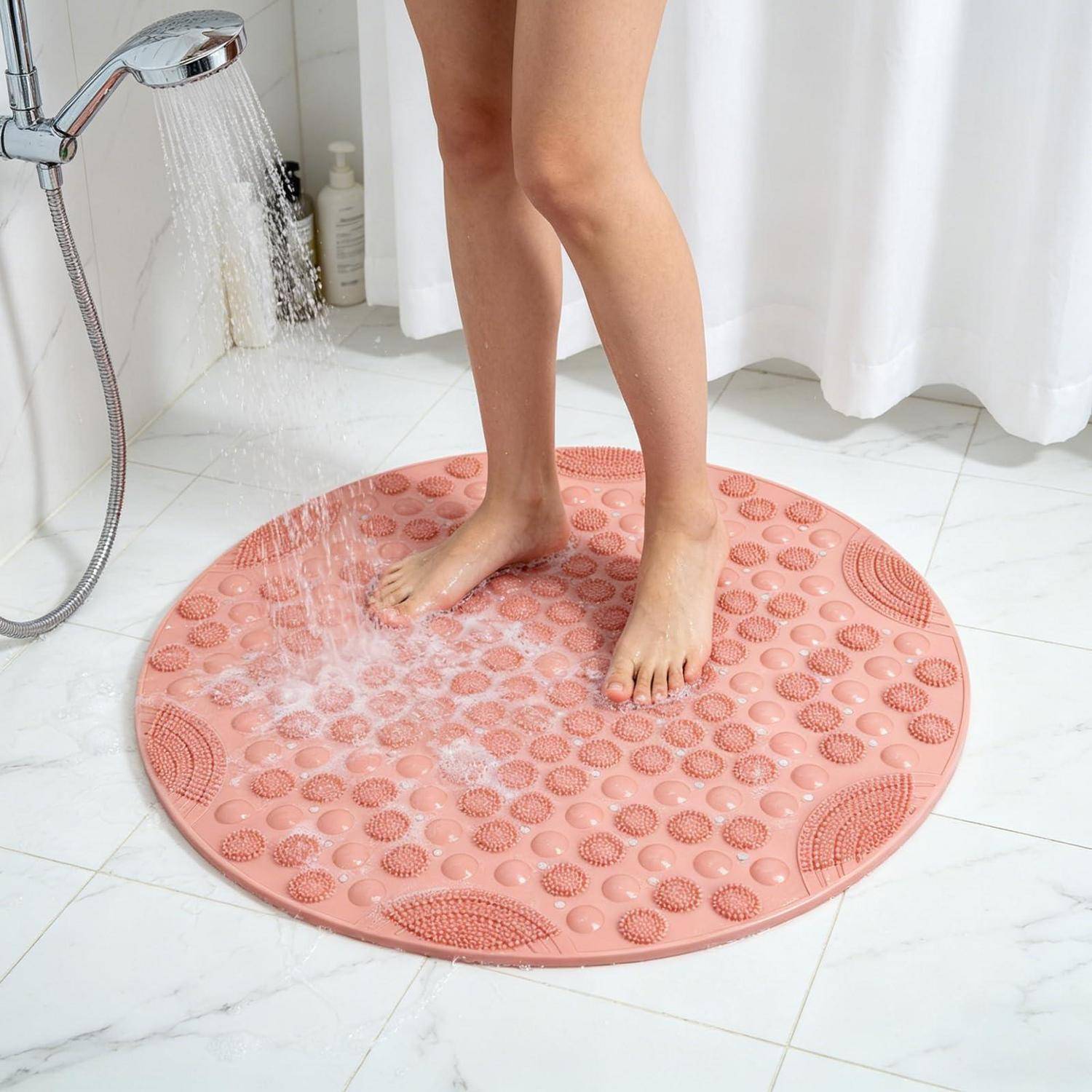 Person, die Füße auf einer rosa runden strukturierten Badematte in einem Duschbereich abspült.