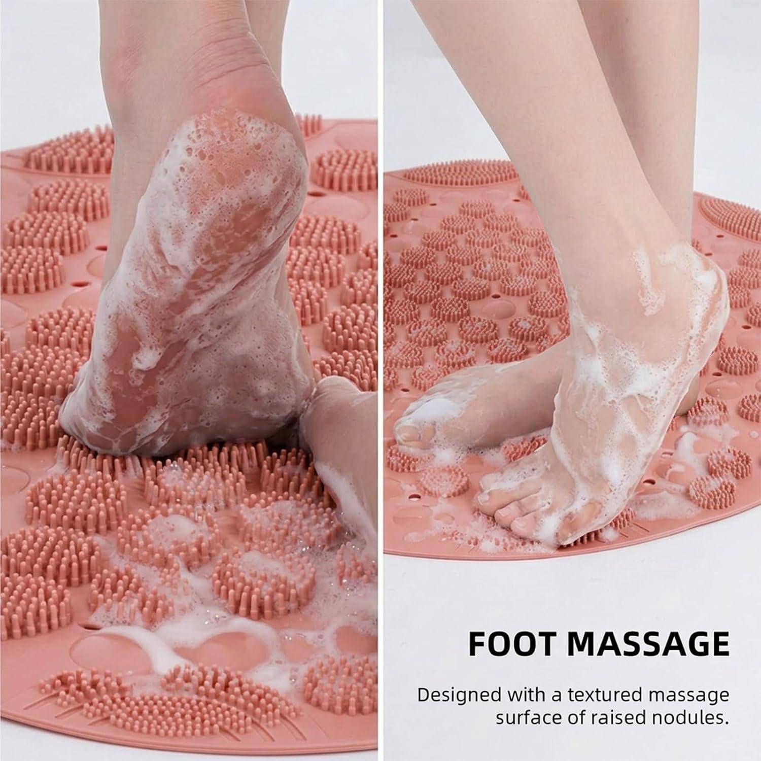 Füße auf einer rosa strukturierten Massagematte mit erhöhten Noppen und Seifenschaum; Der Produkttext lautet „FUSS-MASSAGE" und „Entworfen mit einer strukturierten Massagefläche mit erhöhten Noppen"".