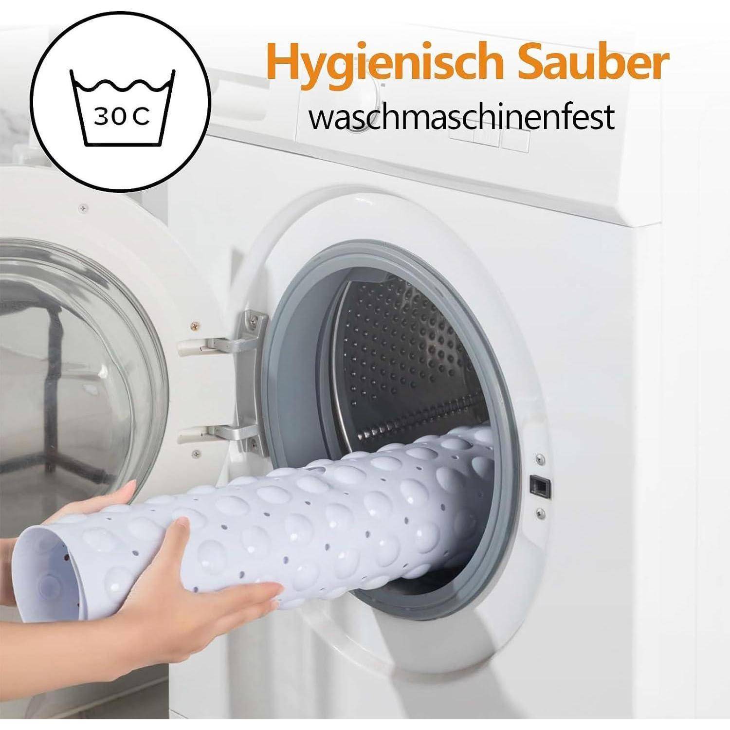 Person, die eine weiße perforierte Badematte in eine Waschmaschine legt, mit Text „Hygienisch Sauber" und „waschmaschinenfest"" und einem 30°C-Wäschesymbol.
