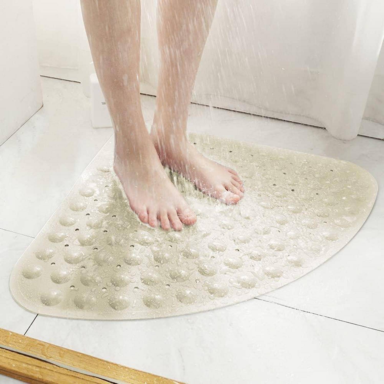 Eine Person steht auf einer strukturierten rutschfesten Badewannenmatte, während ein Duschkopf Wasser über ihre Füße und Beine sprüht.