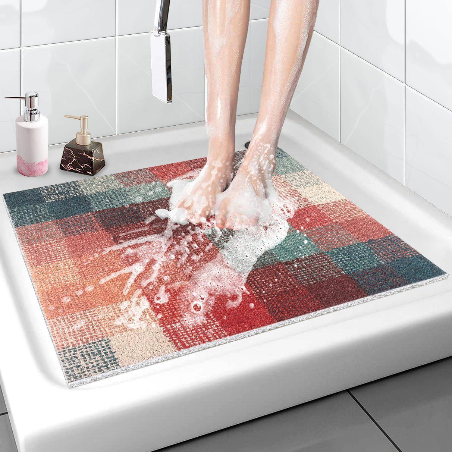 Nackte Füße, die in einer weißen Badewanne gewaschen werden, stehend auf einer farbenfrohen karierten Badmatte mit Seifenschaum und Badezimmerspendern in der Nähe.