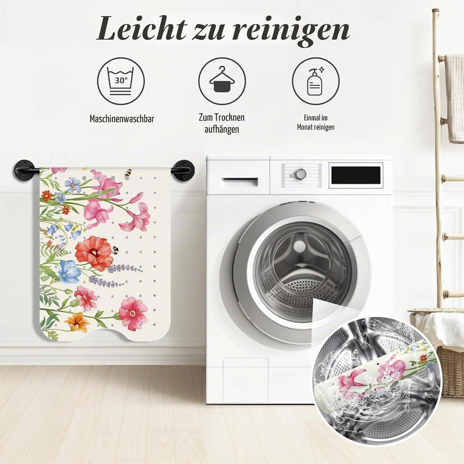 Werbebild einer blumigen Waschmaschinenabdeckung neben einer Frontladewaschmaschine, mit deutschem Text, der angibt, dass sie leicht zu reinigen ist, maschinell waschbar ist, zum Trocknen aufgehängt wird und monatlich gereinigt werden sollte.