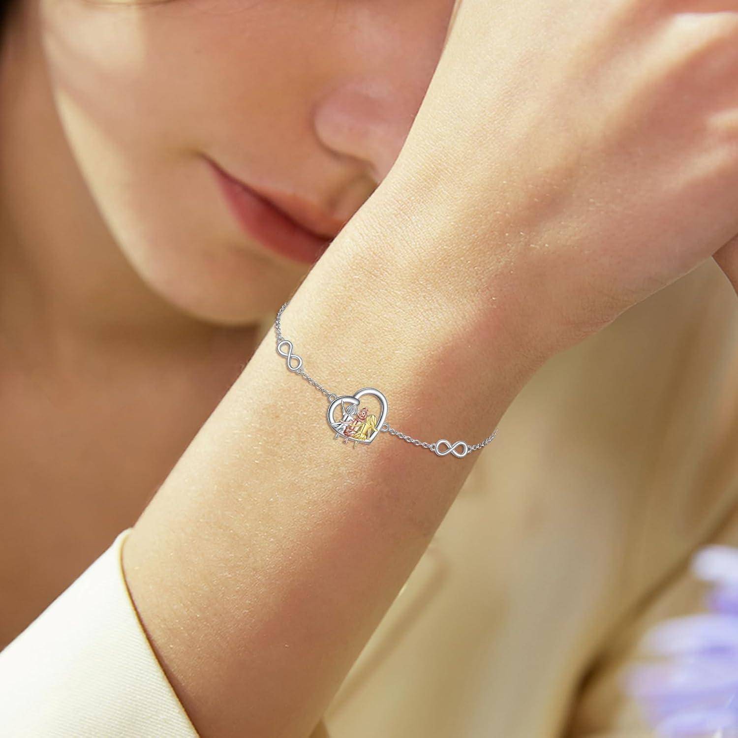 Nahaufnahme einer Person, die ihr Gesicht auf ihren Arm stützt und ein zartes silbernes Armband mit einem Unendlichkeitsanhänger und kleinem Herzanhänger trägt.