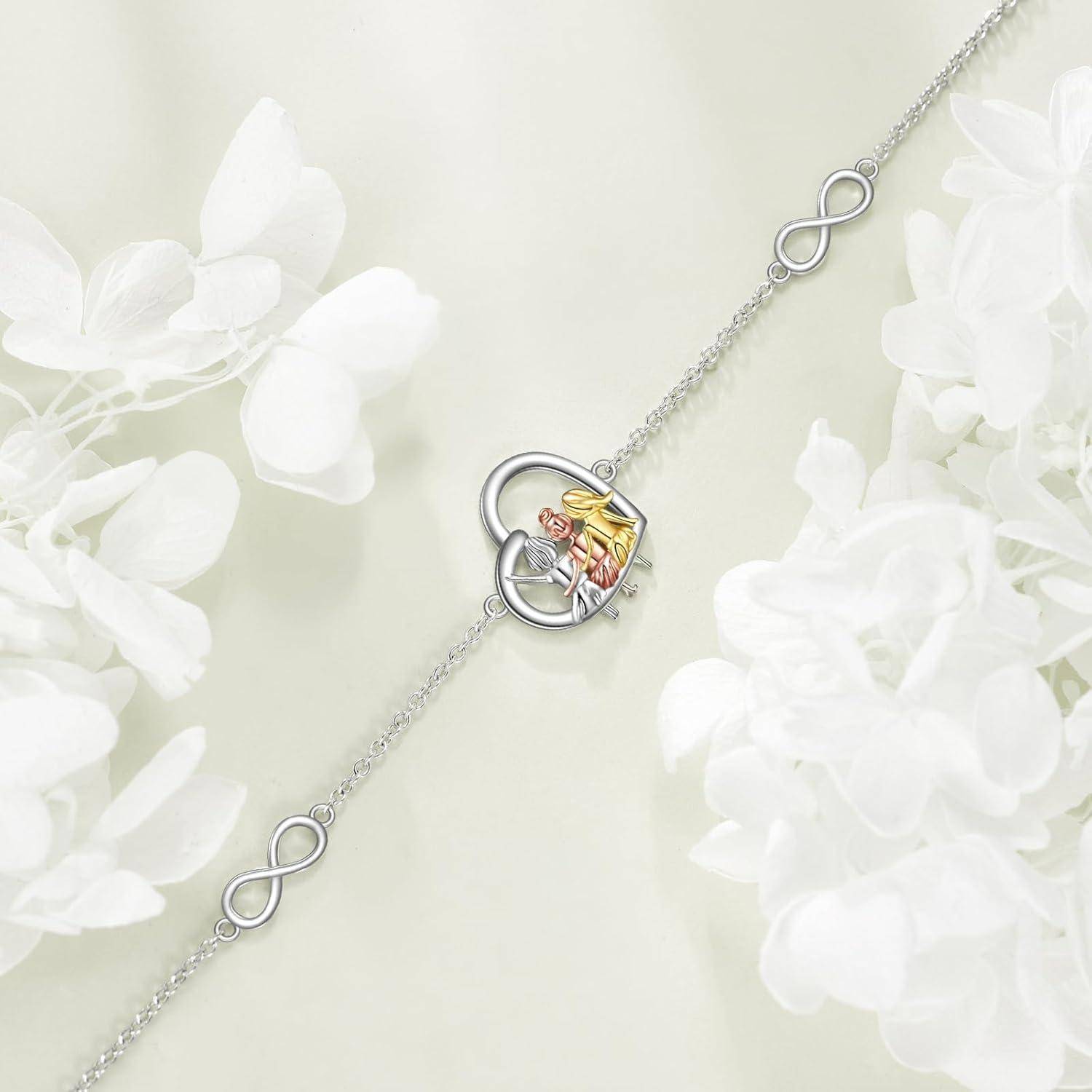 Silberarmband mit Unendlichkeitsgliedern und einer herzförmigen Schließe, an der ein kleiner, farbenfroher Engel- oder Feenanhänger befestigt ist, gezeigt auf einem weichen Blumenhintergrund.