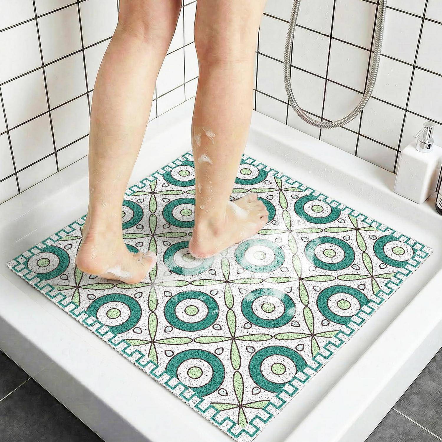 Person steht auf einer gemusterten Antirutschmatte in einer Dusche mit Seifenschaum auf Beinen und Füßen.