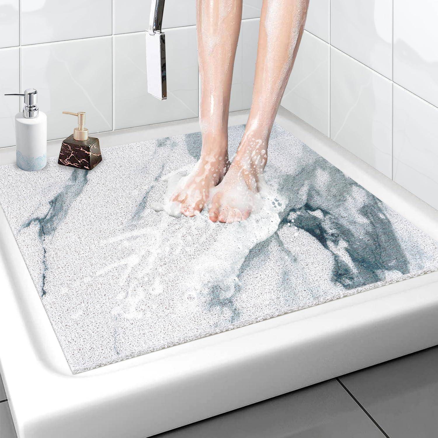Füße, die auf eine gepolsterte Duschmatte in einem gefliesten Badezimmer treten, mit Seifenspendern neben der Badewanne.