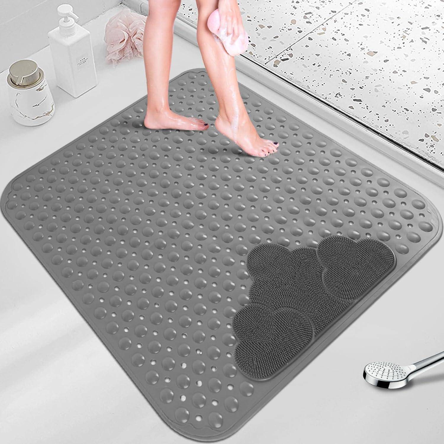 Graue Badematte mit Antirutsch-Oberfläche und Saugnäpfen, dargestellt in einem Badezimmer, während eine Person mit dem Fuß darauf tritt und diesen trocknet.