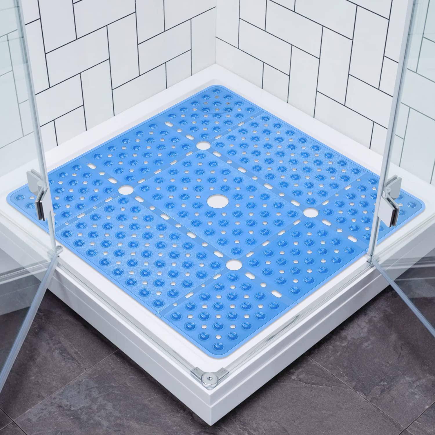 Eckdusche mit blauem rutschfestem Duschtablett und Glastüren in einem weiß gekachelten Badezimmer