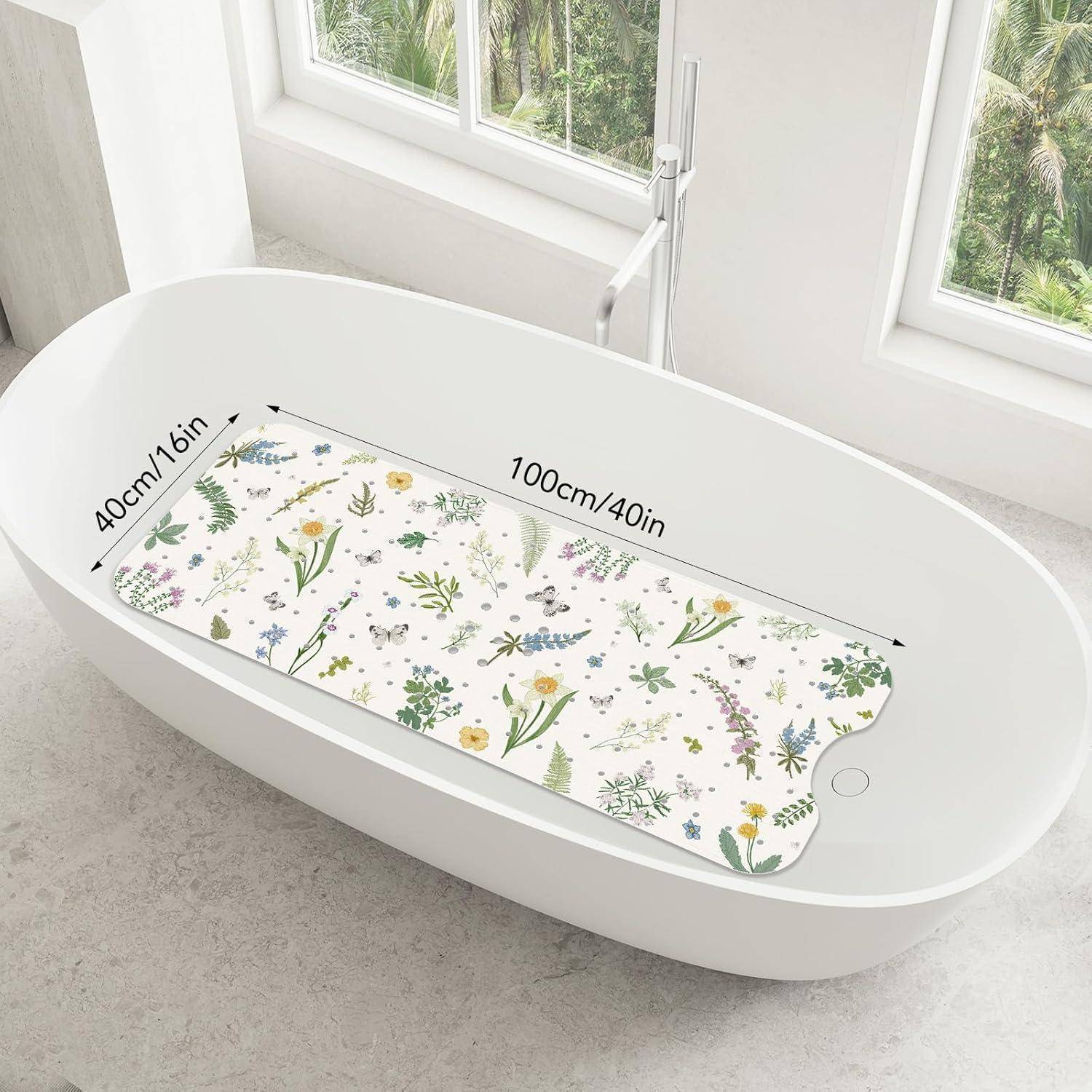 Blumenbadematte in einer weißen freistehenden Badewanne, mit der Beschriftung 100 cm x 40 cm, die ihre Größe und gekrümmte Form zeigt.