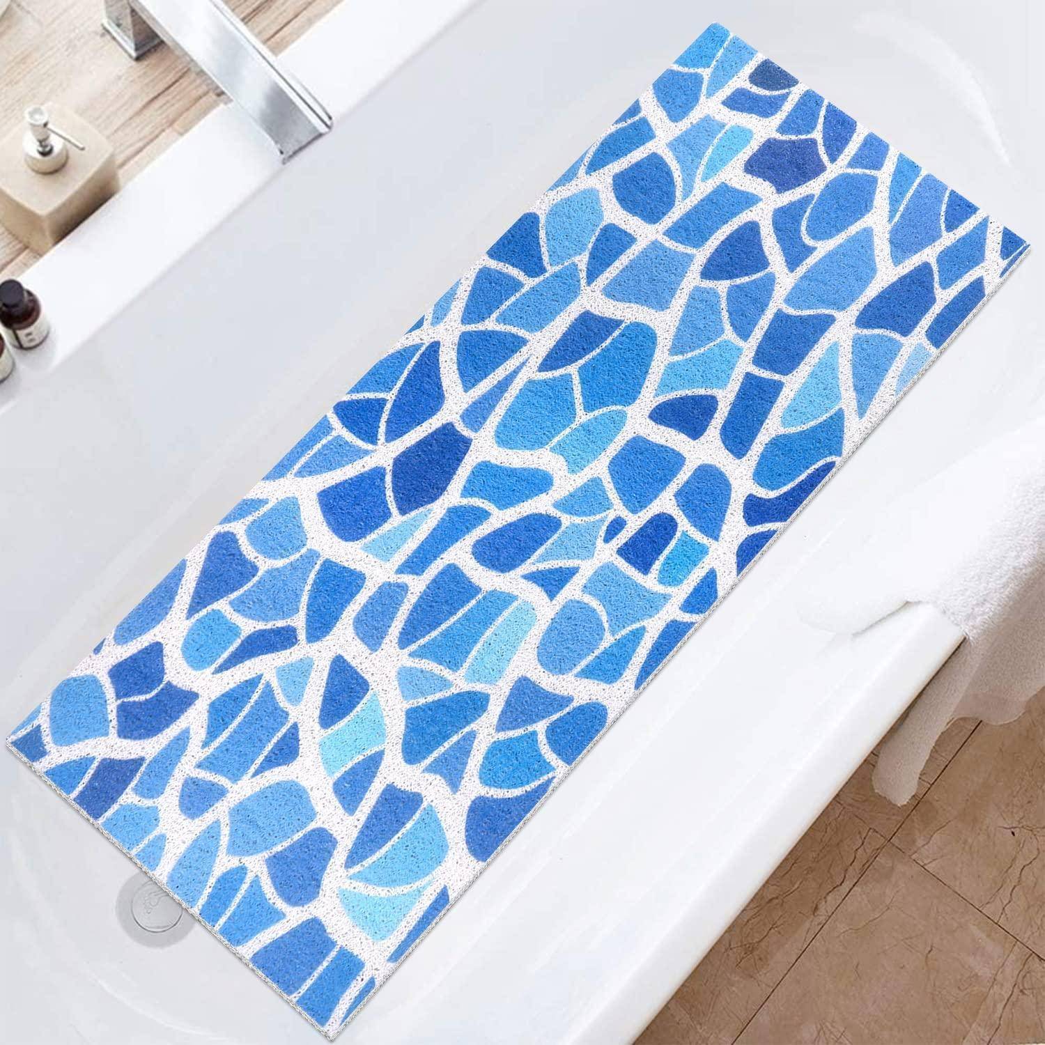 Blaue Badeteppich mit Mosaikmuster auf der weißen Badewannenkante im Badezimmer.