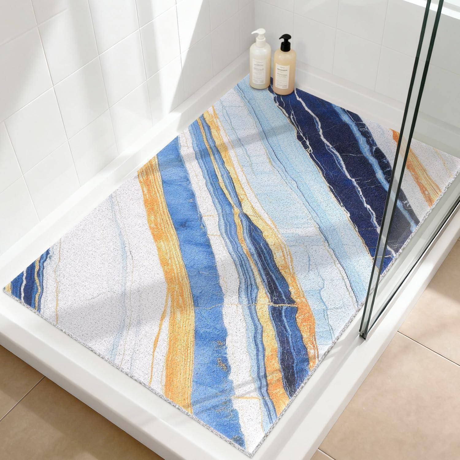 Weißer Duschboden mit einer Badmatte in Blau-, Gold- und Marineblau-Streifen und zwei Pumpflaschen in der Ecke.