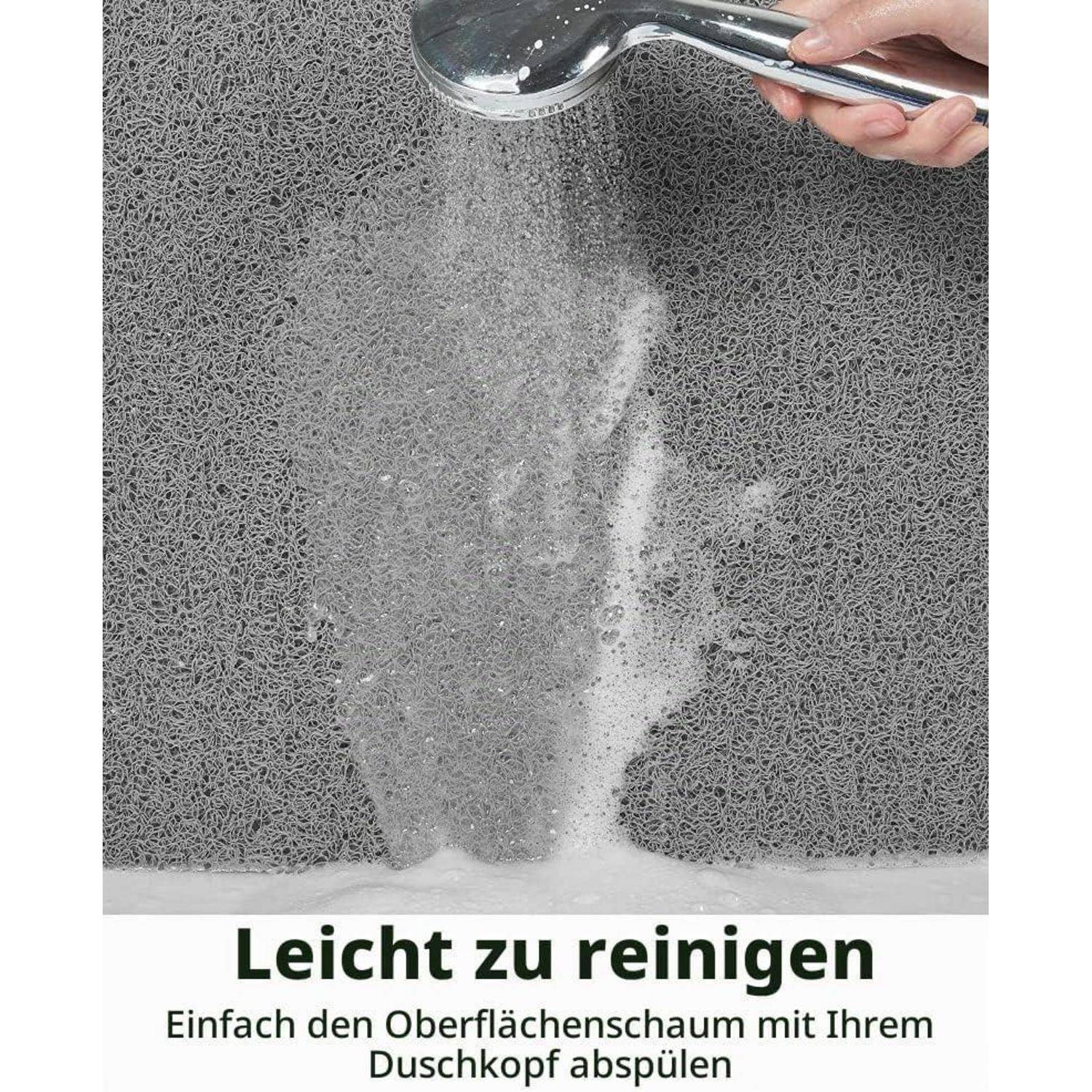 Handheld-Duschkopf spült eine graue Schaumbadeteppich; deutscher Text liest sich „Leicht zu reinigen