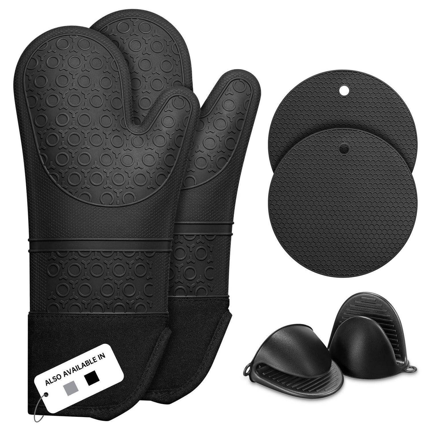 Schwarze Silikonofenhandschuhe, runde Topflappen und kleine Fingerschutzvorrichtungen zusammen als hitzebeständige Küchenzubehöre ausgestellt.