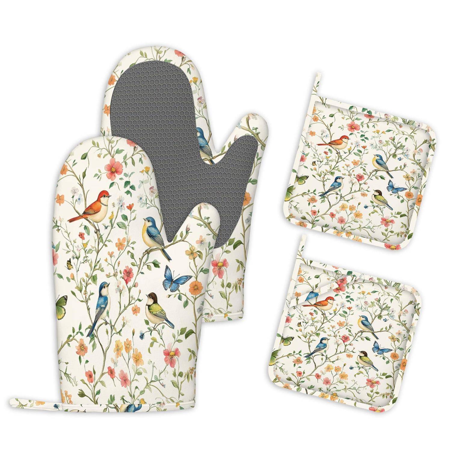 Gemusterter Ofenhandschuh, Topflappen und passende Küchenmatten mit Blumen- und Vogelmotiven auf weißem Grund.