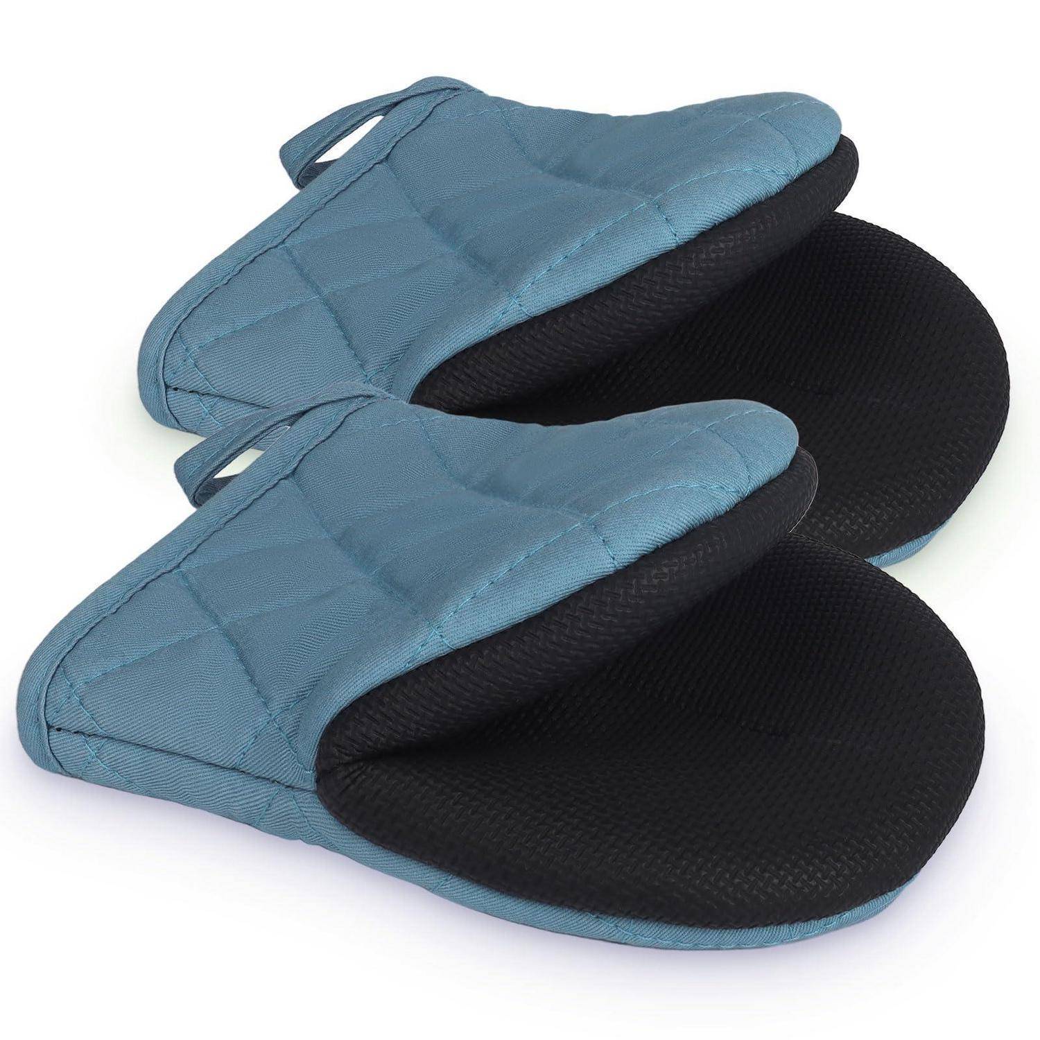 Paar blaue gesteppte Slip-On-Pantoffeln mit schwarzen strukturierten Einlegesohlen, gezeigt auf weißem Hintergrund.