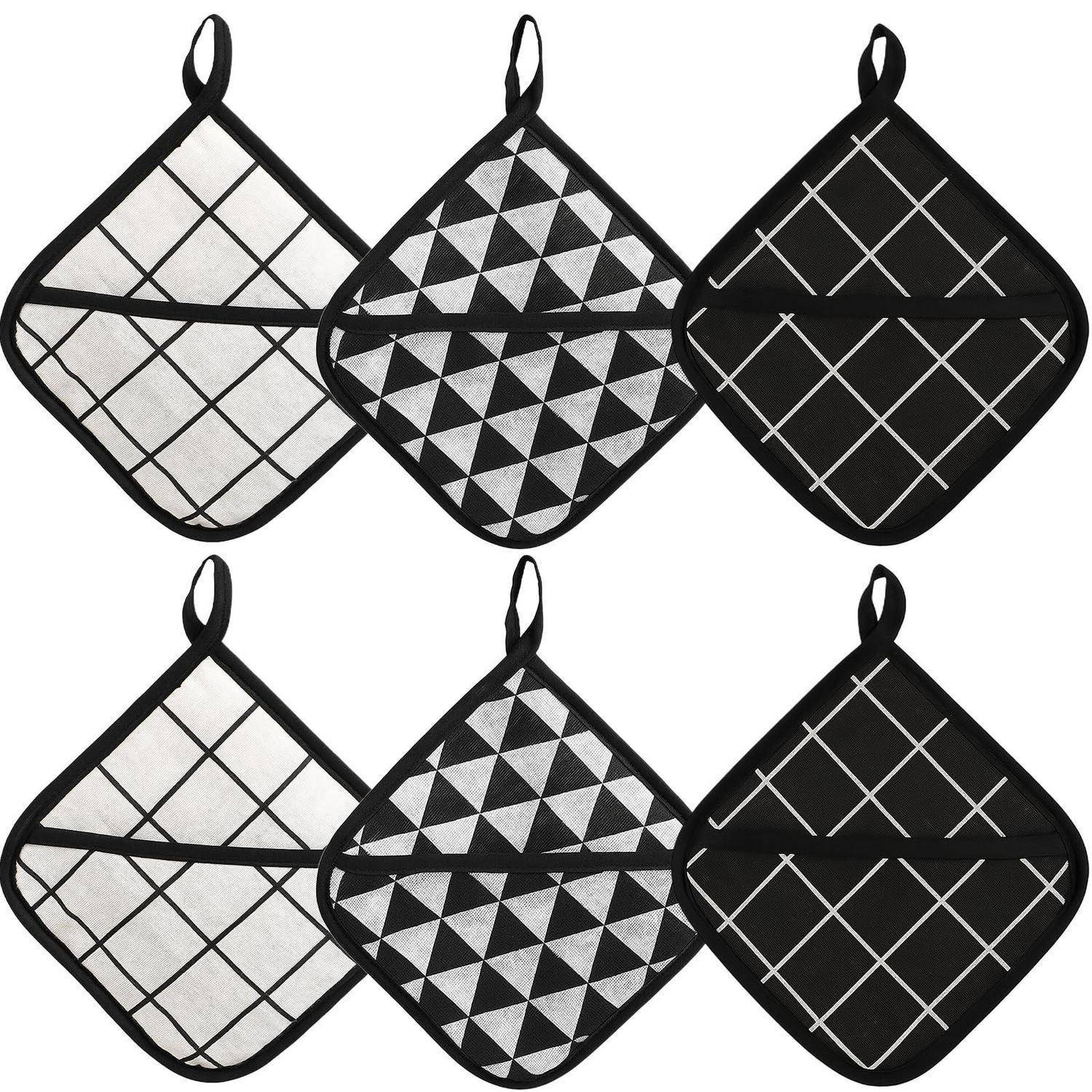 Sechs diamantförmig gesteppte Ofenhandschuhe oder Topflappen in schwarz-weißen geometrischen Mustern, angeordnet in zwei Reihen zu je drei.