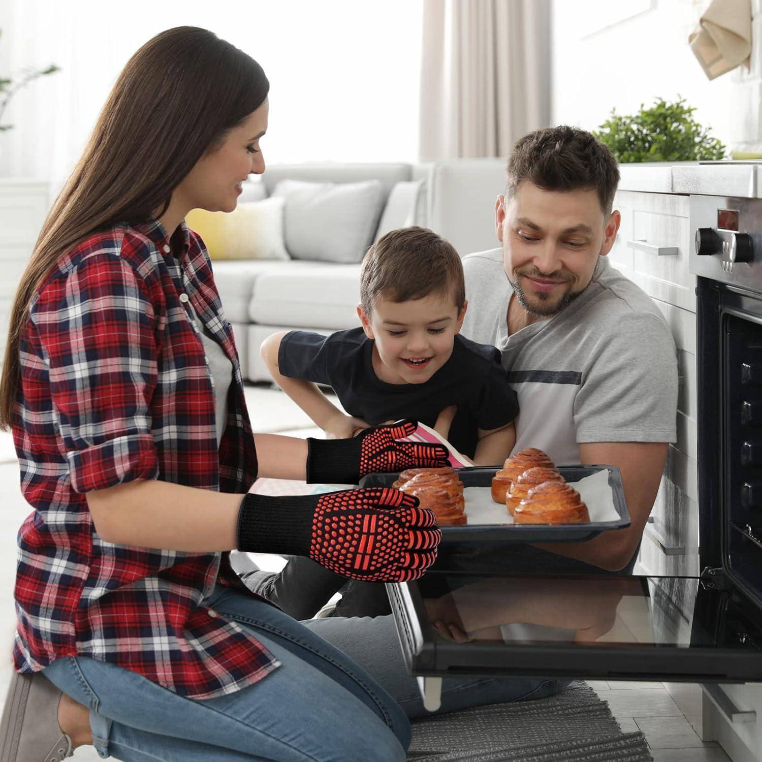 Familie, die frisch gebackene Gebäckstücke auf einem Ofenrost in einer Heimatküche platziert, wobei ein Kind zwischen zwei Erwachsenen hilft.