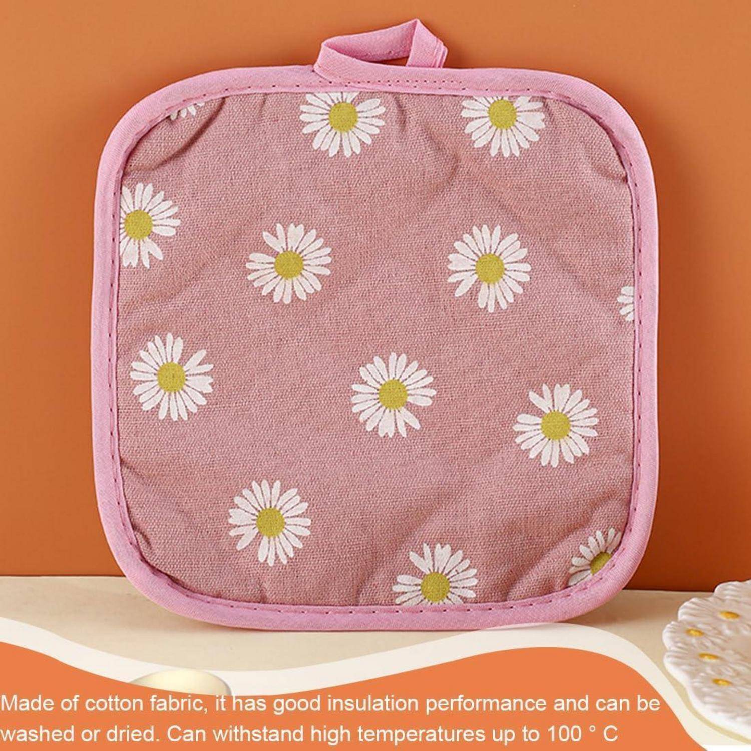 Rosa isolierte Lunchbox mit weißem Gänseblümchenmuster auf orangefarbenem Hintergrund, dargestellt mit Text, der Baumwollstoff und Wärmespeicherung beschreibt.