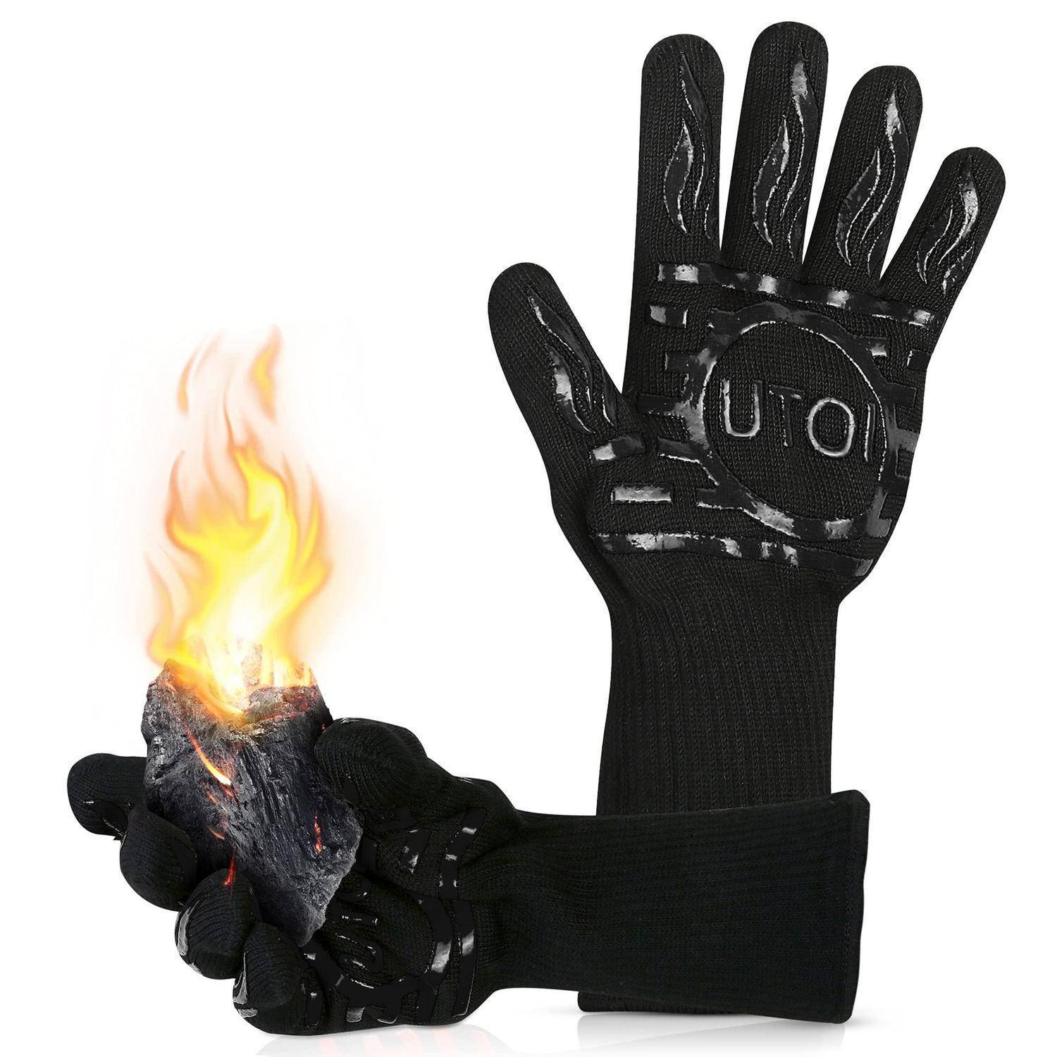 Schwarzer hitzebeständiger Handschuh hält eine brennende Kohle oder Glut, zeigt Feuerschutz.