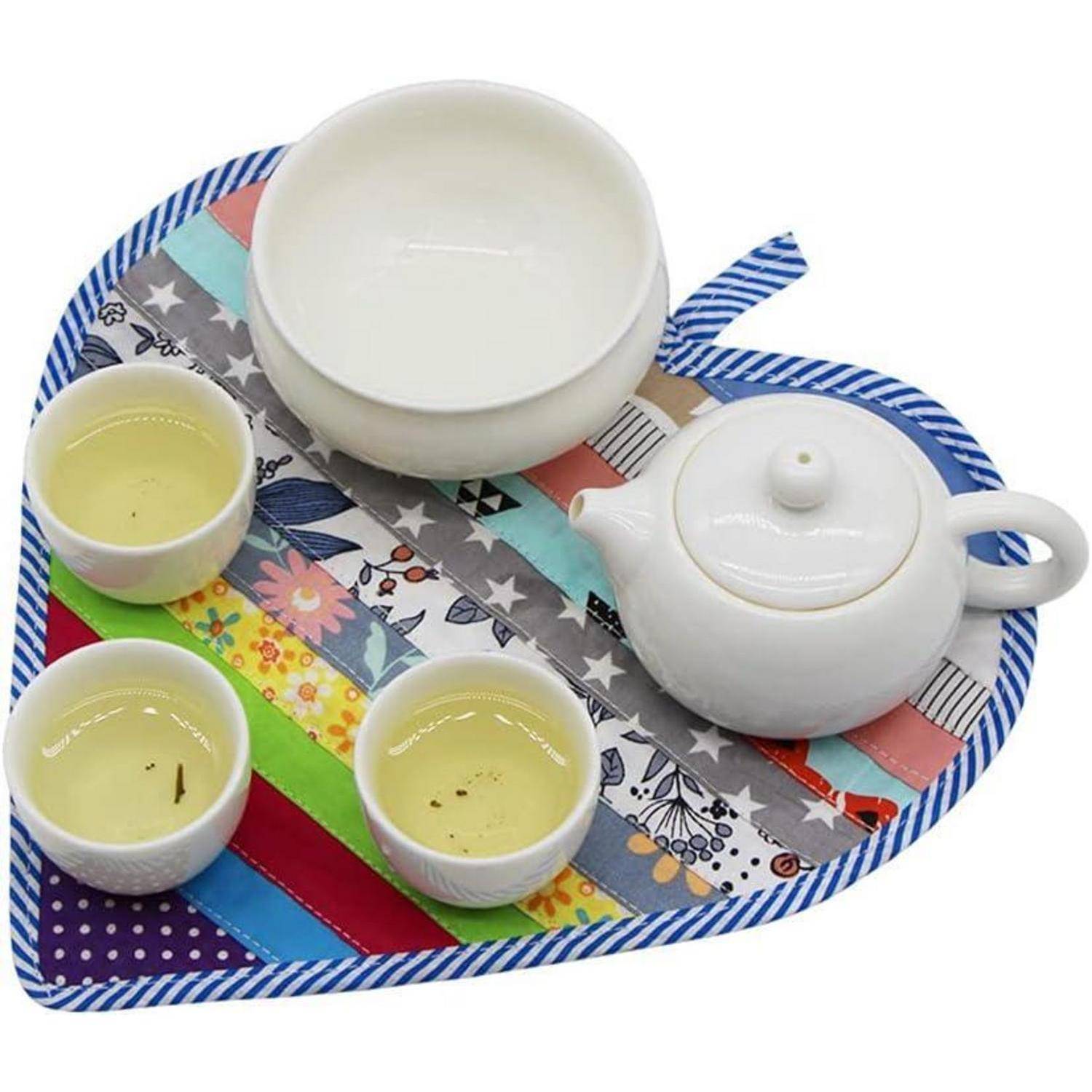 Weiße Teeset mit Teekanne, Schüssel und drei Tassen auf einem farbenfrohen gestreiften Tablett mit blauem Rand.