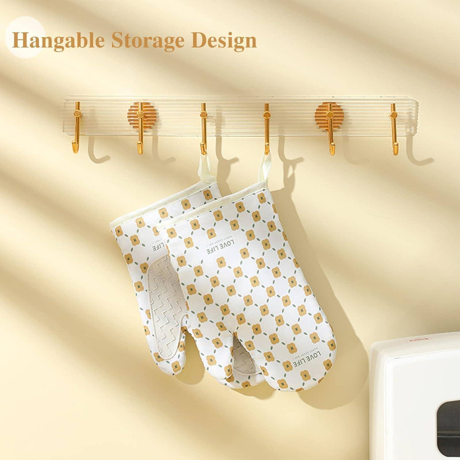 Wandmontiertes Hängeregal mit mehreren Haken, an denen ein gemusterter Backhandschuh und Fäustlinge hängen, mit der Beschriftung „Hangable Storage Design