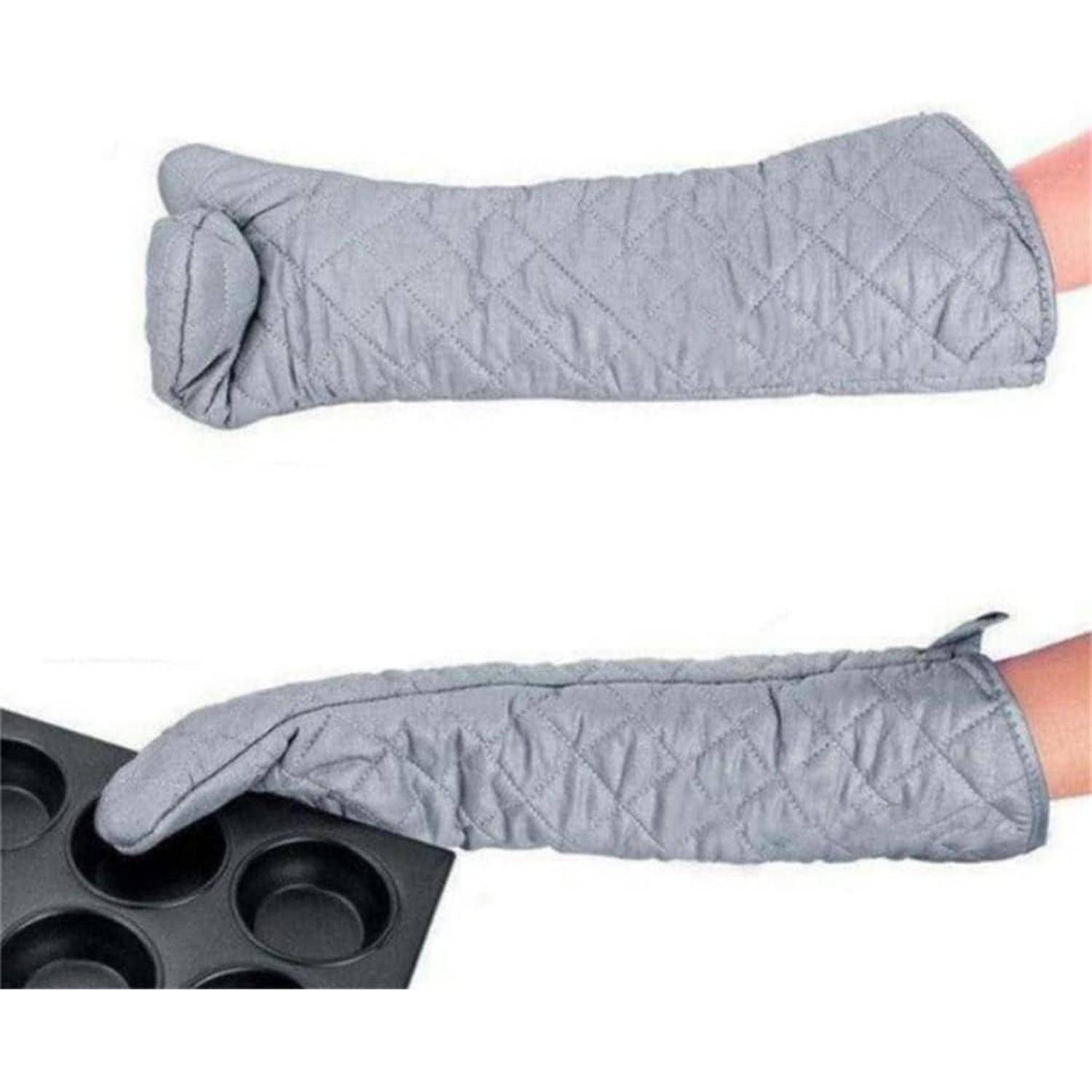 Grauer gesteppter Ofenhandschuh, der bis zum Unterarm reicht, wird gezeigt, wie er einen Arm bedeckt und in der Nähe eines heißen Muffinblechs hält.
