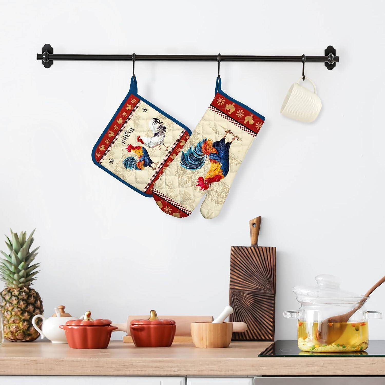 Küchenwandhalter mit zwei Backhandschuhen mit Hahnenmuster und einem hängenden Halter über einer Arbeitsplatte mit Ananas, Kochgeschirr, Schneidebrett und einem Glas mit Lebensmitteln.