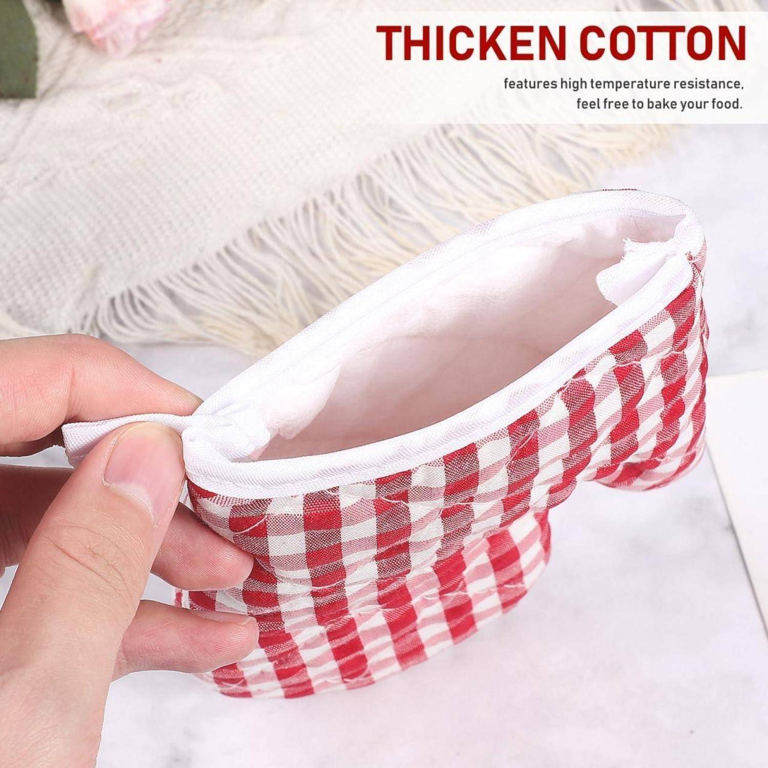 Hand hält einen rot-weiß karierten dicken Baumwoll-Backbecher, gezeigt als hitzebeständig zum Backen von Lebensmitteln.