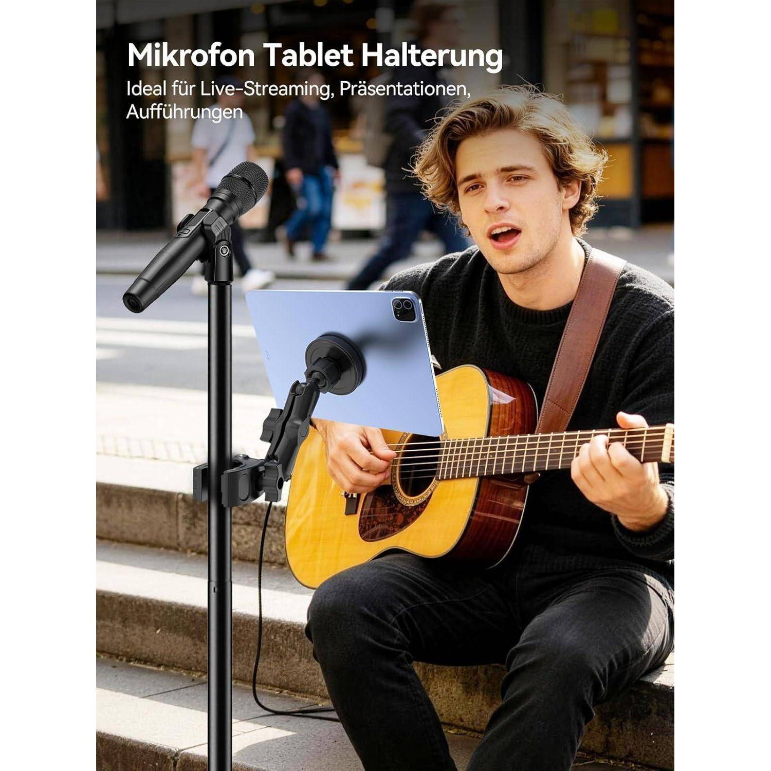 Ein Straßenmusiker singt und spielt Akustikgitarre neben einem Tablet auf einem Mikrofonständer; deutscher Text bewirbt „Mikrofon Tablet Halterung" für Live-Streaming und Präsentationen.