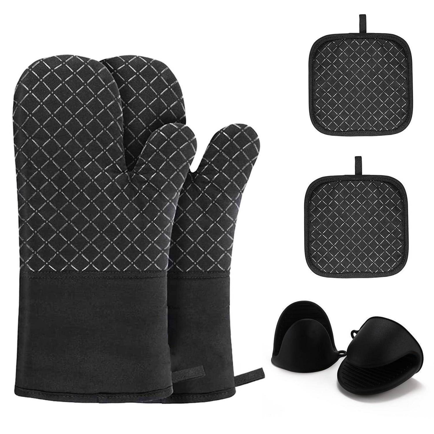 Schwarze gesteppte Ofenhandschuhe mit zwei passenden quadratischen Topflappen und einem Paar schwarzer Silikon-Griffzangen auf weißem Hintergrund.