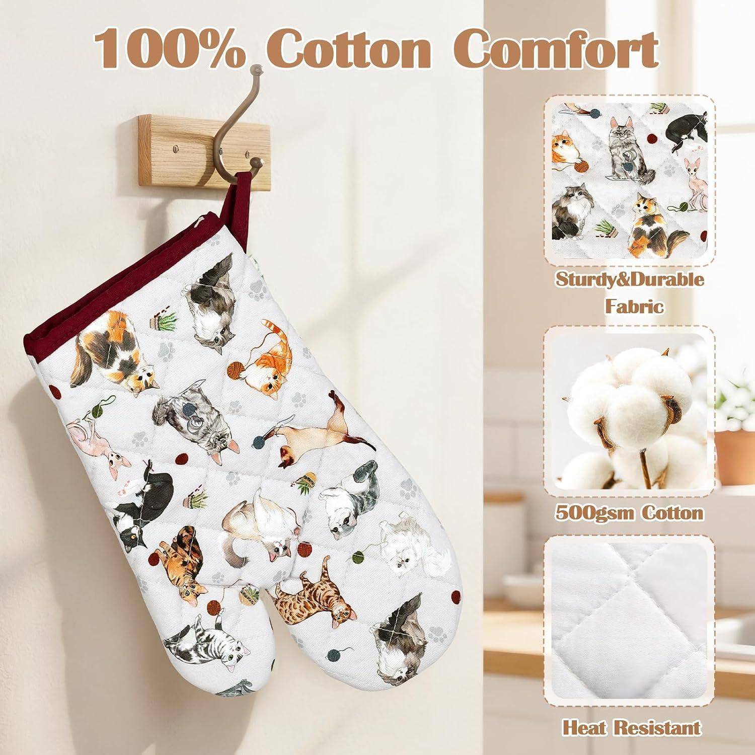 Werbebild eines Ofenhandschuhs und einer passenden Topflappen mit Katzenmuster, die an einer Wand hängen, mit den Bezeichnungen „100% Baumwolle Komfort