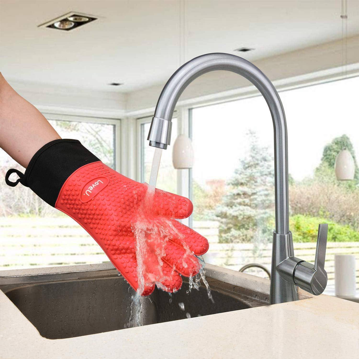 Eine Person spült einen roten Ofenhandschuh unter einem Küchenwasserhahn am Spülbecken ab.
