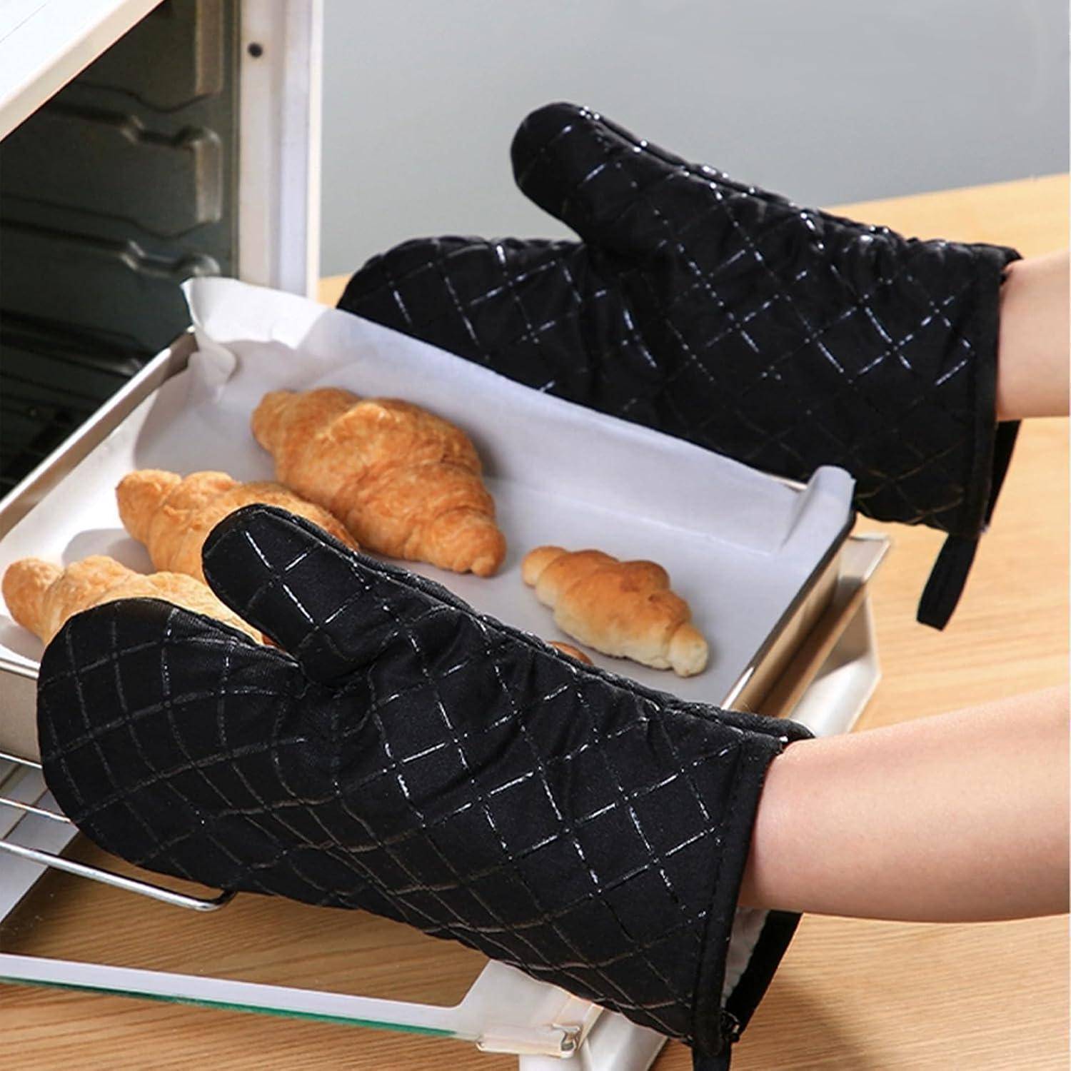 Ofenhandschuhe halten ein Backblech mit frisch gebackenen Croissants und Brötchen.