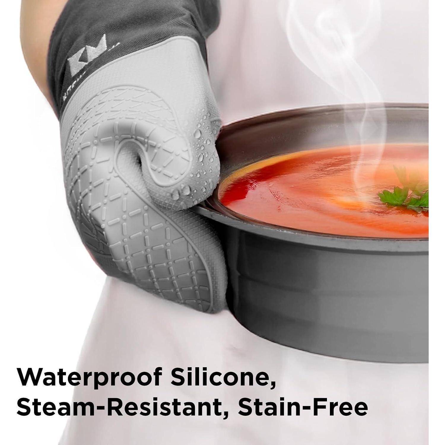 Graue Silikon-Ofenhandschuh hält einen dampfenden Topf mit roter Suppe; Text lautet „Wasserdicht Silikon, dampfresistent, fleckenabweisend