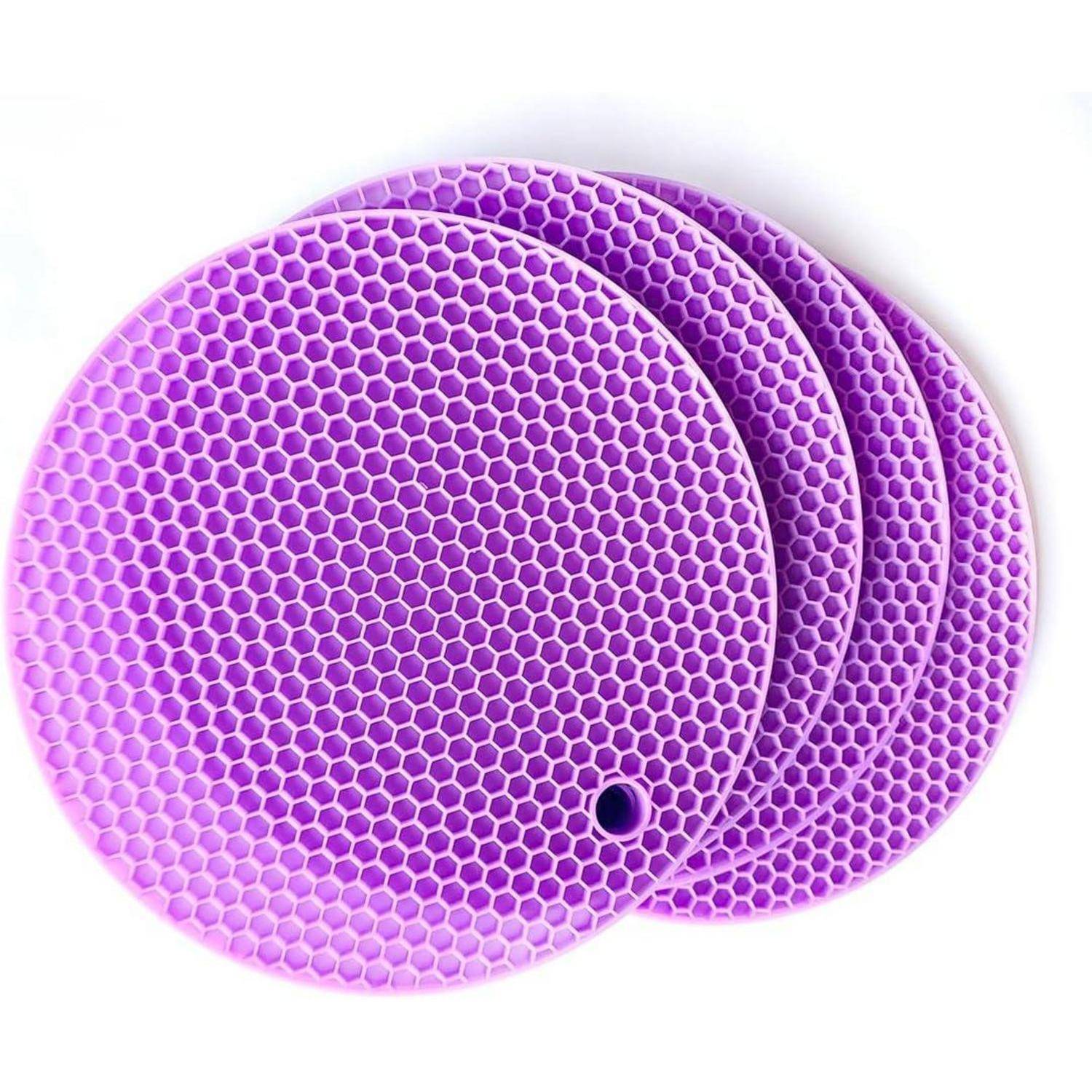 Drei überlappende violette Matten mit Wabenstruktur und runder Form mit einem kleinen Loch in der Nähe der Kante der vorderen Matte.